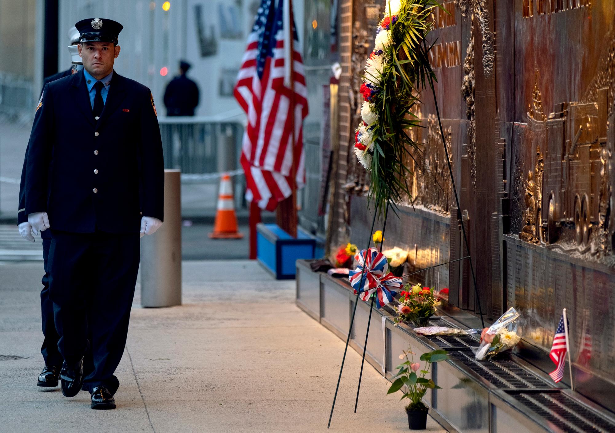 Los bomberos de la ciudad de Nueva York se colocan frente a un monumento conmemorativo al lado de una estación de bomberos adyacente al One World Trade Center y el sitio del 9/11 Memorial durante las ceremonias que conmemoran el 18 aniversario de los ataques terroristas del 11 de septiembre en Nueva York, 11 de septiembre de 2019. 