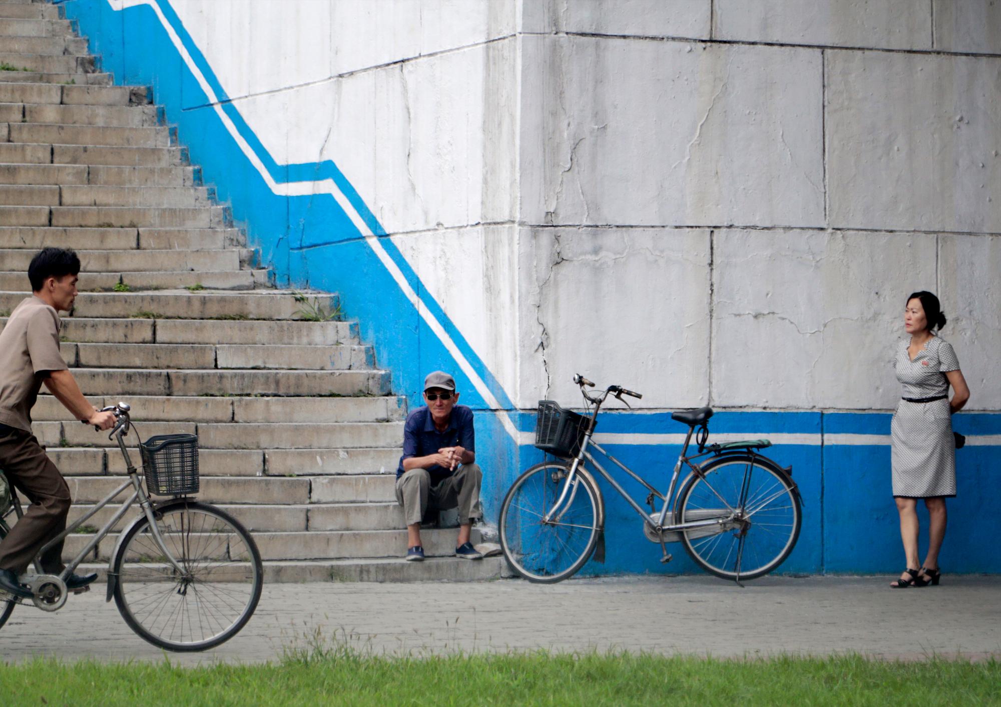 Un hombre se sienta con su bicicleta debajo de un puente en Pyongyang, Corea del Norte, el jueves 12 de septiembre de 2019. 