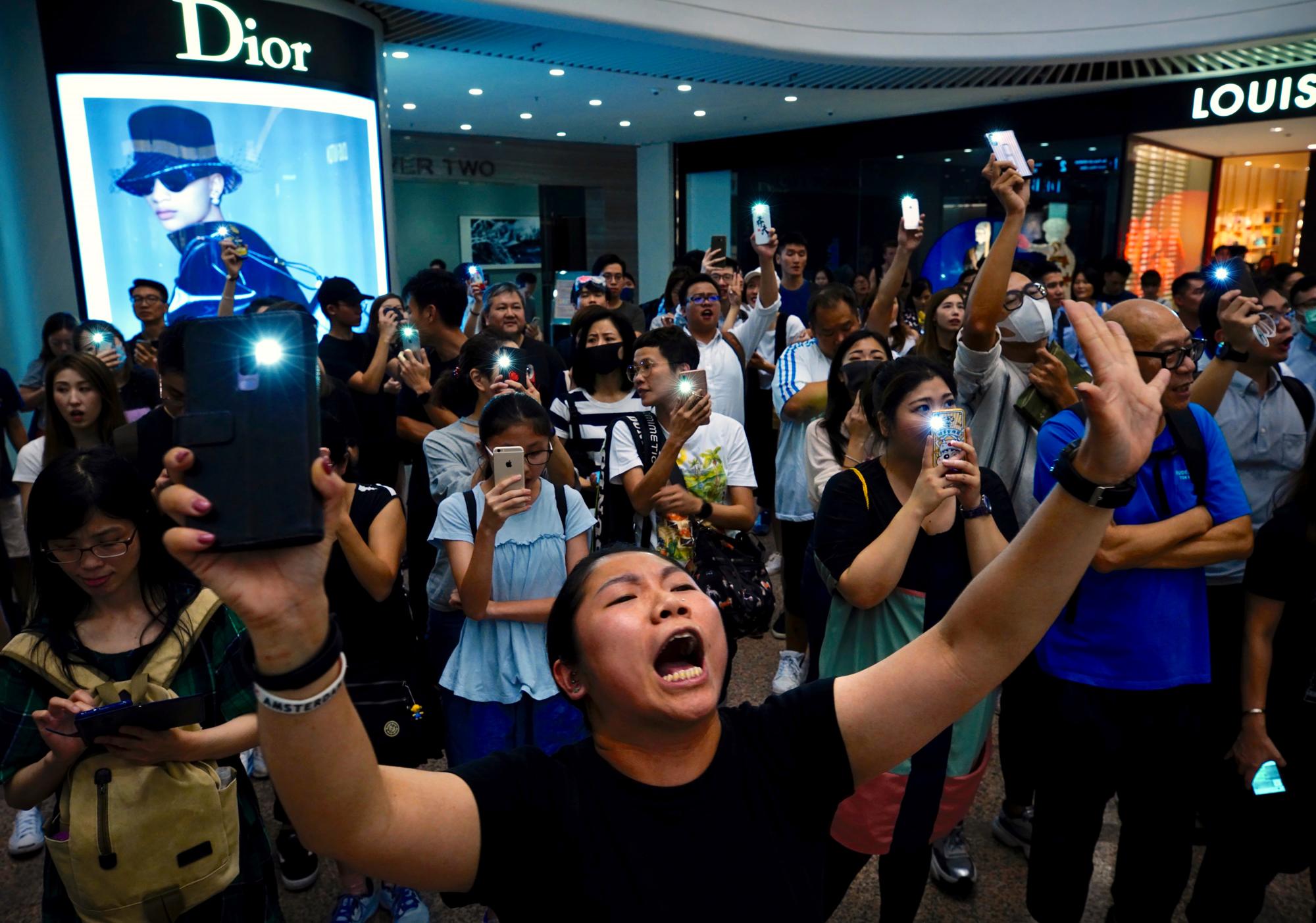 Los manifestantes cantan un tema musical escrito por los manifestantes “Gloria a Hong Kong” en el centro comercial Times Square en Hong Kong, el jueves 12 de septiembre de 2019. Miles de personas cantaron una nueva canción de protesta en los centros comerciales de Hong Kong en un acto de resistencia que destacó la creatividad de los manifestantes en su lucha de meses por las libertades democráticas en el territorio chino semiautónomo.