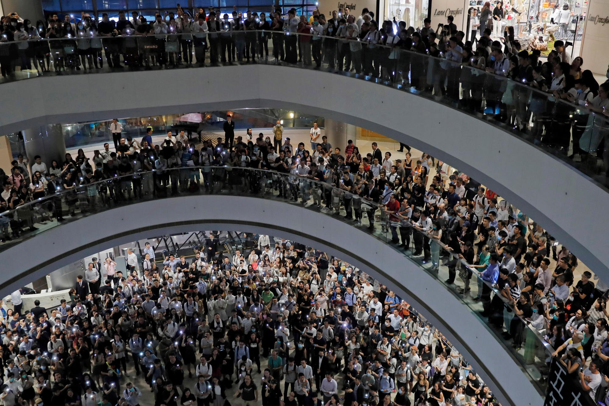 Los manifestantes cantan un tema musical escrito por los manifestantes “Gloria a Hong Kong” en el centro comercial Times Square en Hong Kong, el jueves 12 de septiembre de 2019. Miles de personas cantaron una nueva canción de protesta en los centros comerciales de Hong Kong en un acto de resistencia que destacó la creatividad de los manifestantes en su lucha de meses por las libertades democráticas en el territorio chino semiautónomo. 