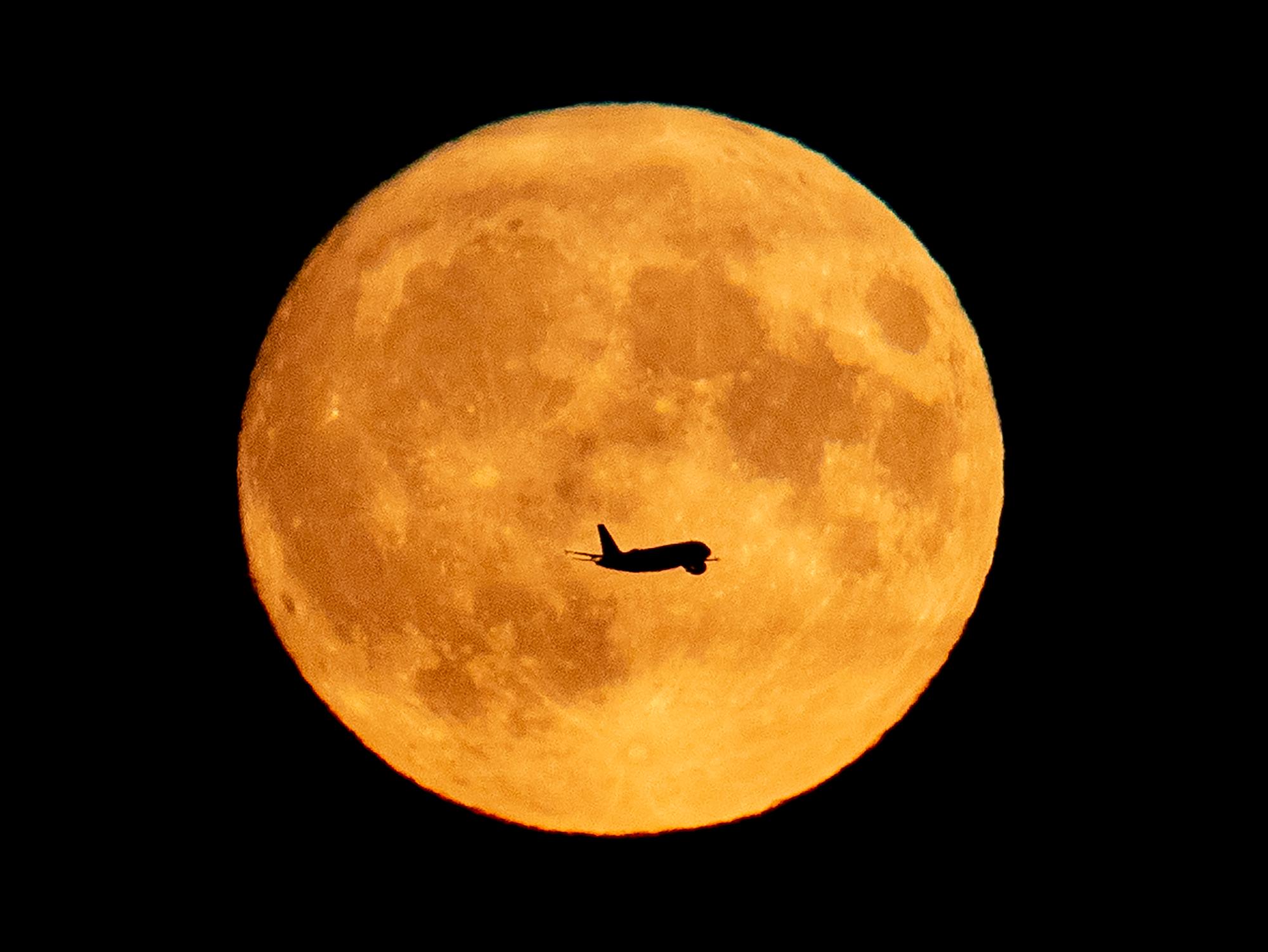 Un avión pasa la luna llena cuando se acerca al aeropuerto de Frankfurt, Alemania, el viernes 13 de septiembre de 2019. 