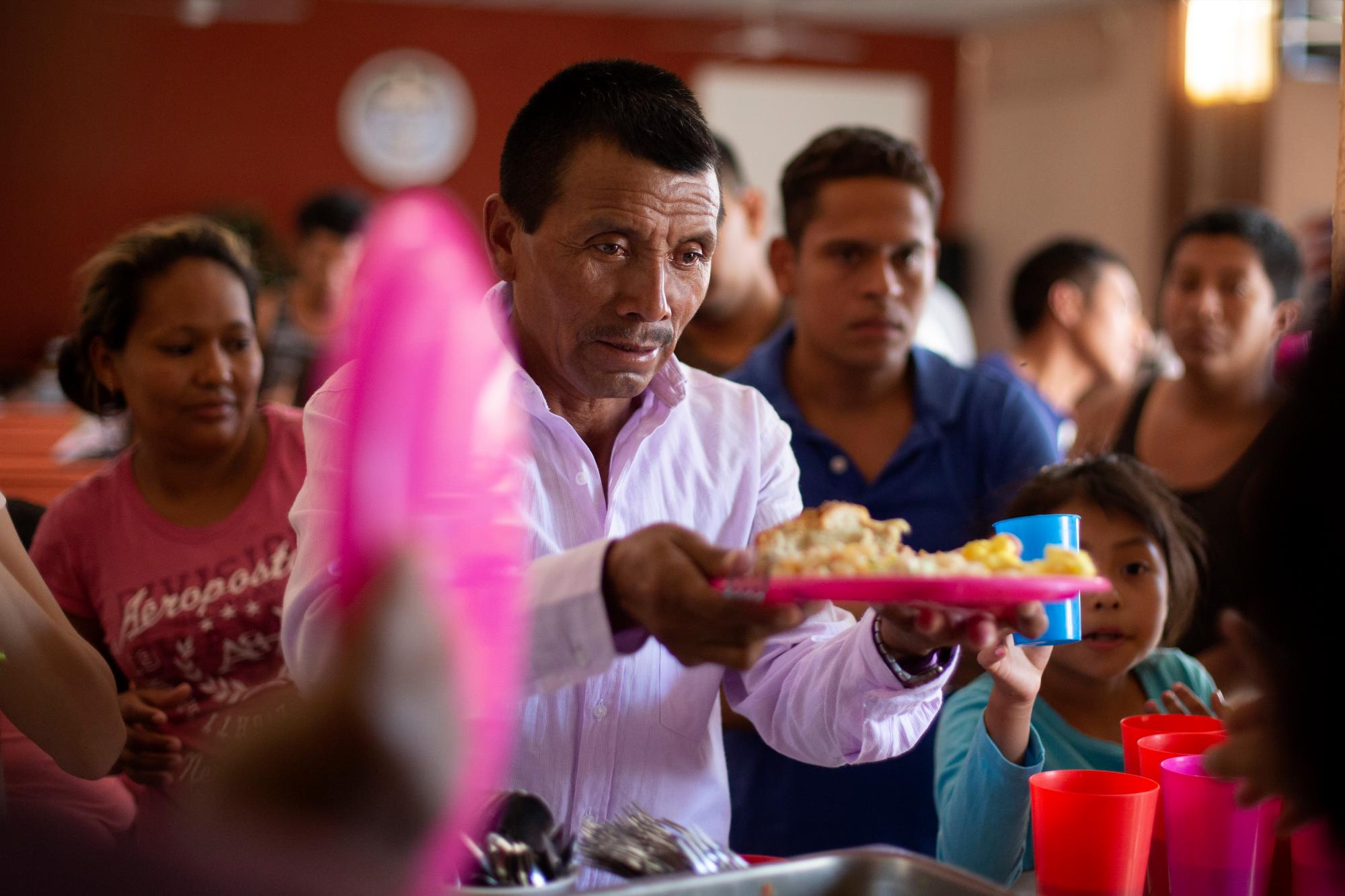 En esta foto del 25 de julio de 2019, un hombre guatemalteco obtiene un plato de comida en el refugio El Buen Pastor para migrantes en Ciudad Juárez, México. 
