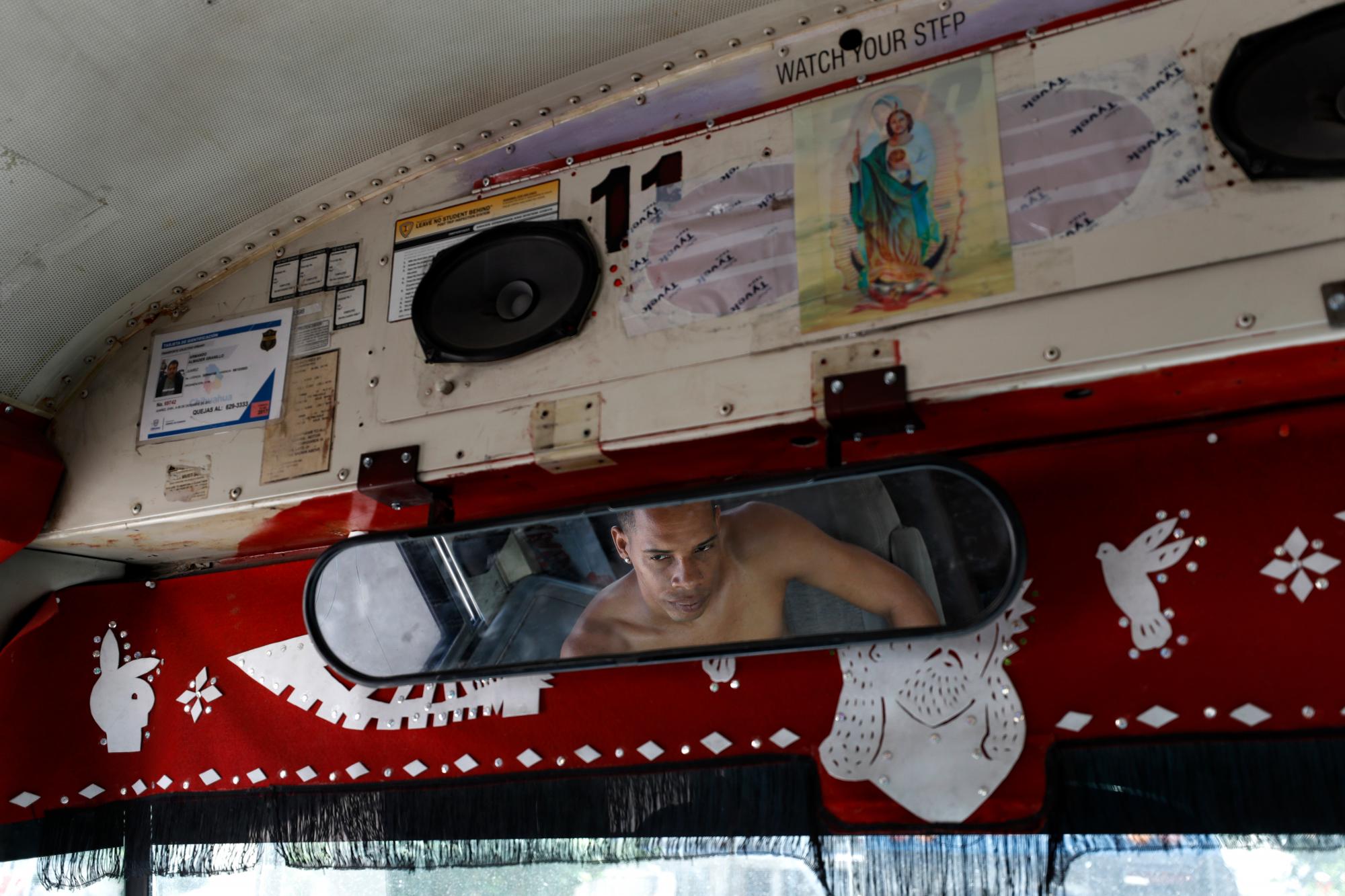 En esta foto del 31 de julio de 2019, un migrante de Cuba pasa el día escuchando música en un autobús escolar convertido estacionado cerca del refugio El Buen Pastor para migrantes en Ciudad Juárez, México. 
