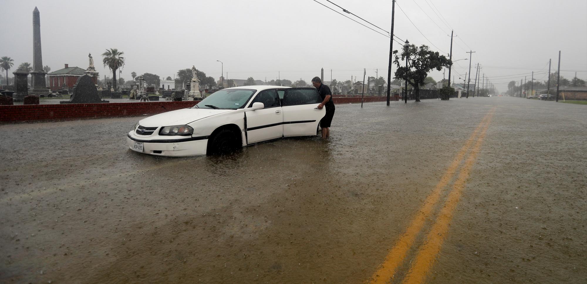 Angel Marshman abre la puerta trasera de su automóvil inundado mientras se encuentra en aguas de la depresión tropical Imelda el miércoles 18 de septiembre de 2019 en Galveston, Texas. 