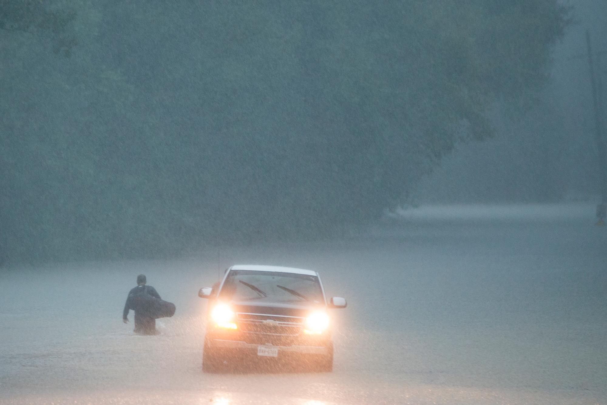 Un hombre camina hacia aguas altas en su vecindario cuando la lluvia de la depresión tropical Imelda inundó el área el jueves 19 de septiembre de 2019, cerca de Patton Village, Texas. 
