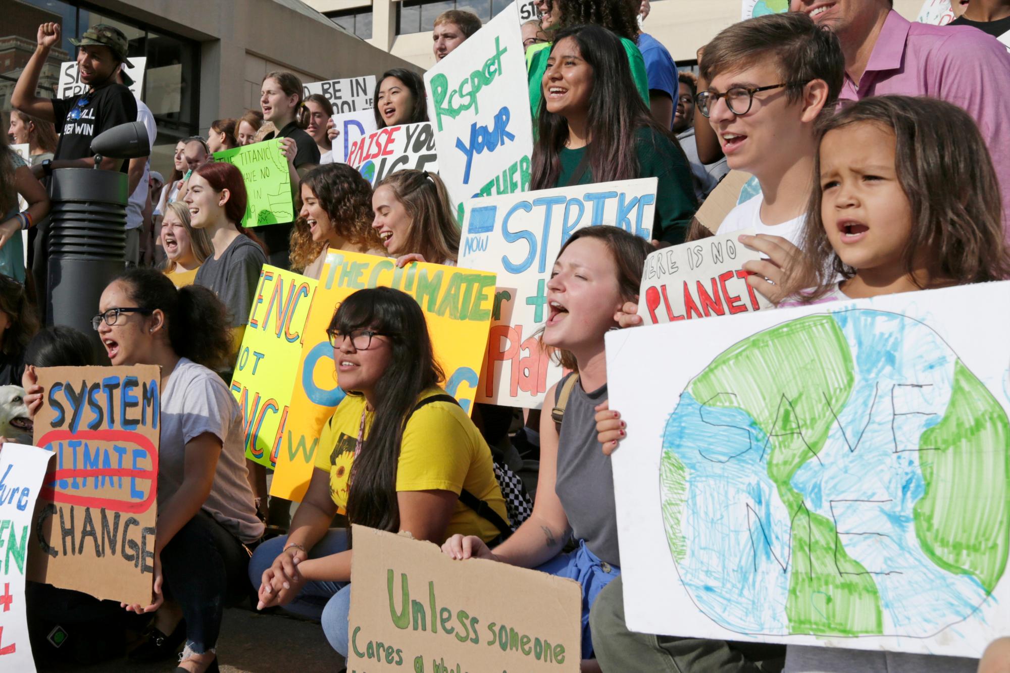 Los jóvenes se manifiestan con pancartas durante una acción de la semana de huelga climática juvenil frente al Ayuntamiento en Omaha, Nebraska, el viernes 20 de septiembre de 2019. En todo el mundo, cientos de miles de jóvenes salieron a las calles el viernes para exigir que los líderes aborden el cambio del clima en el período previo a una cumbre de la ONU. 