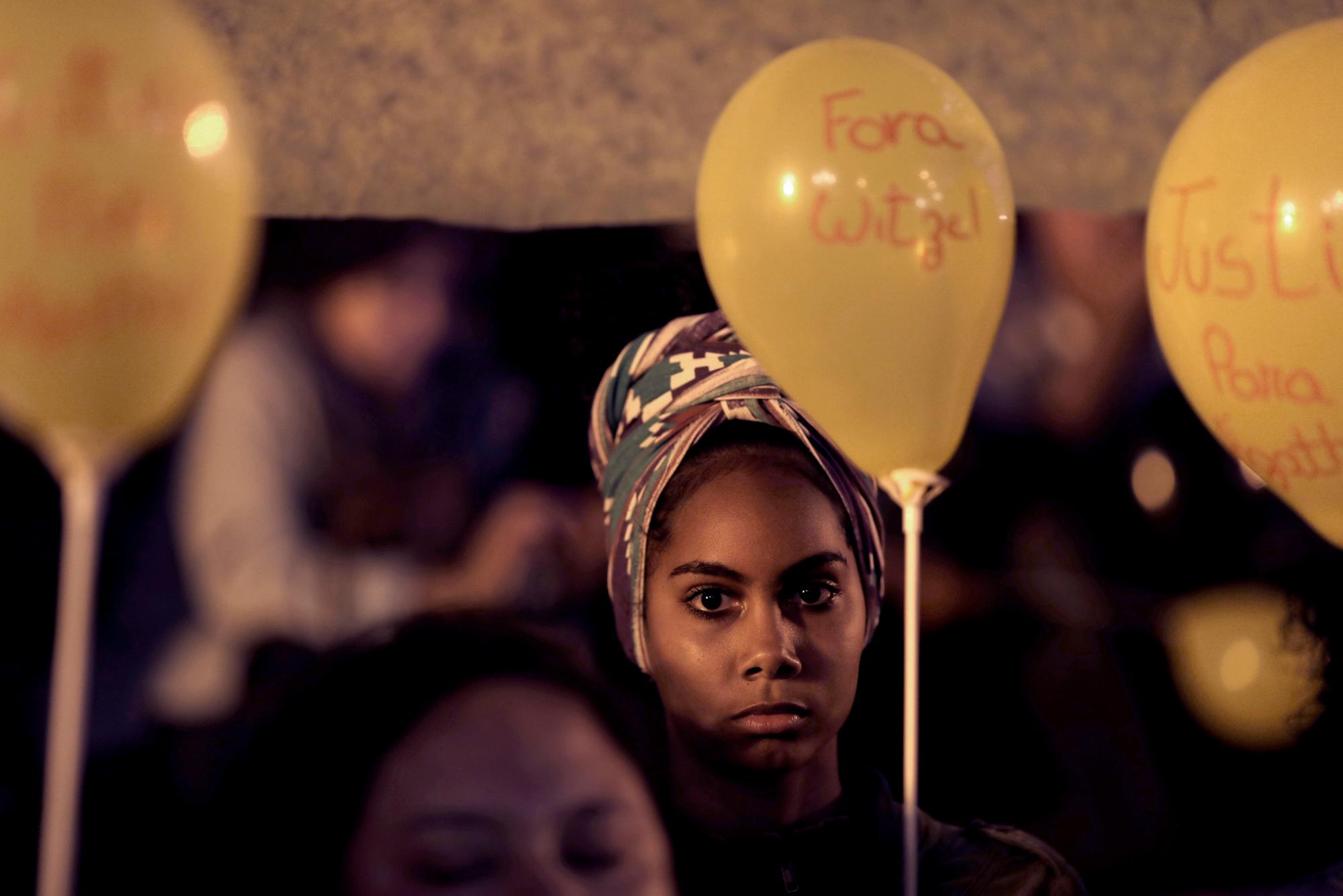 En esta imagen, tomada el 23 de septiembre de 2019, una mujer sostiene un globo amarillo en recuerdo de la niña de 8 años Ágatha Sales Félix durante una protesta contra las fuerzas de seguridad del estado, en Río de Janeiro, Brasil. Ágatha murió por el impacto de una bala perdida, que según denuncias pertenecería a la policía, en la espalda cuando viajaba en una camioneta por la favela de Complexo do Alemao, en Río. (AP Foto/Silvia Izquierdo)