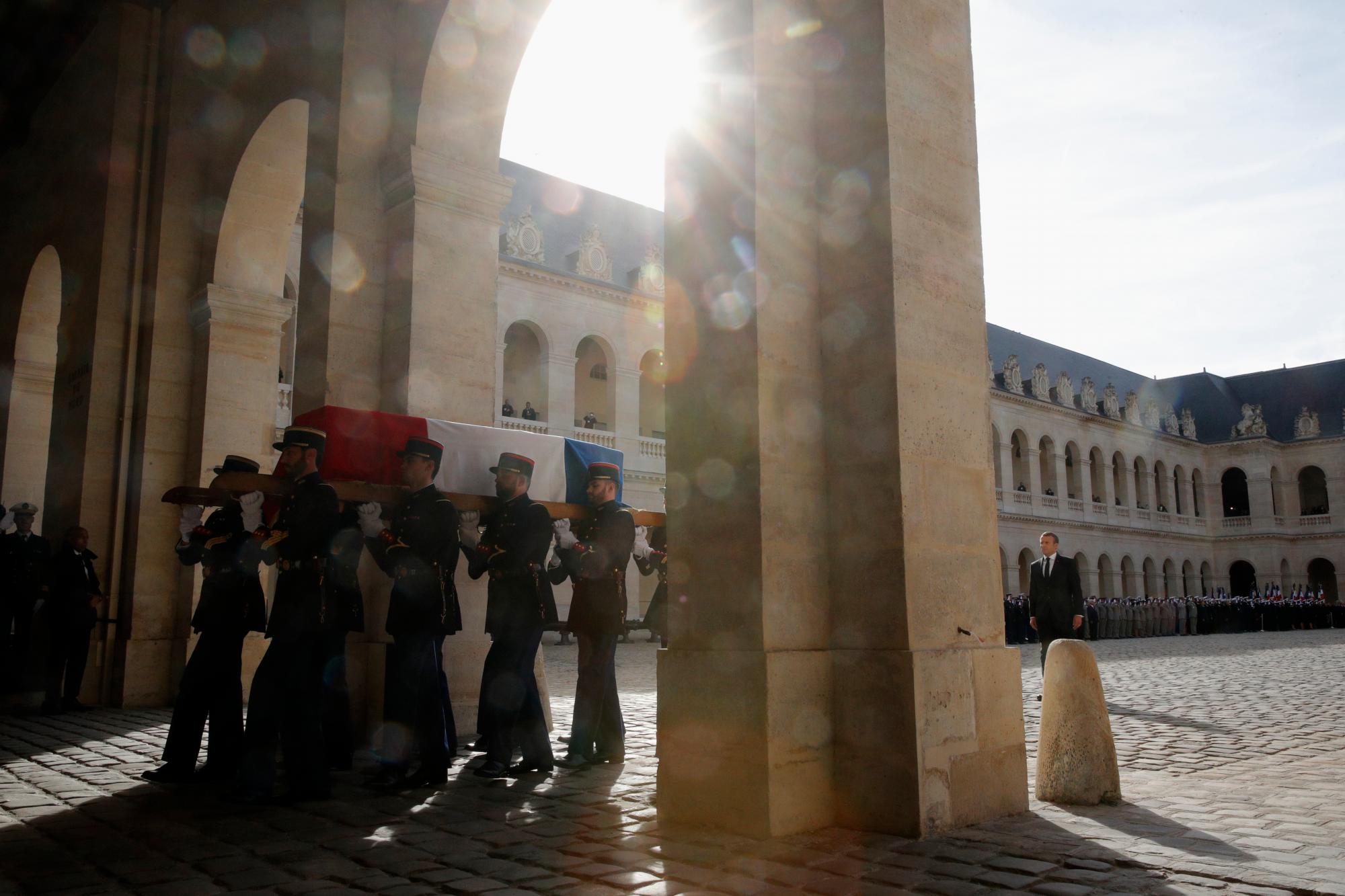 Los guardias republicanos franceses llevan el ataúd cubierto de banderas del fallecido presidente francés Jacques Chirac durante una ceremonia de honores de funeral militar en el monumento de los Inválidos durante un día nacional de luto en París, el lunes 30 de septiembre de 2019. 