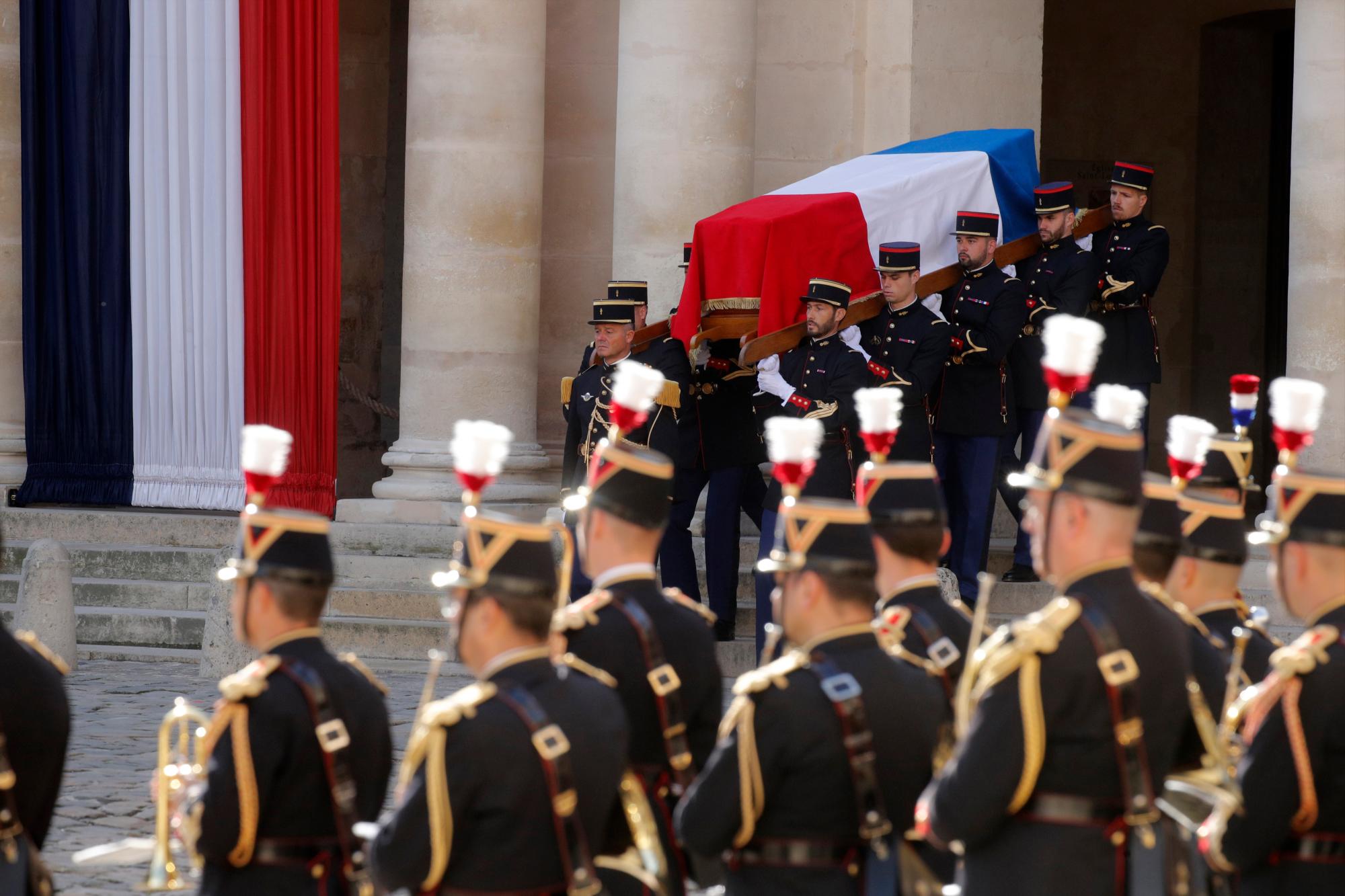 Los guardias republicanos franceses llevan el ataúd cubierto de banderas del fallecido presidente francés Jacques Chirac durante una ceremonia de honores de funeral militar en el monumento de los Inválidos durante un día nacional de luto en París, el lunes 30 de septiembre de 2019. 