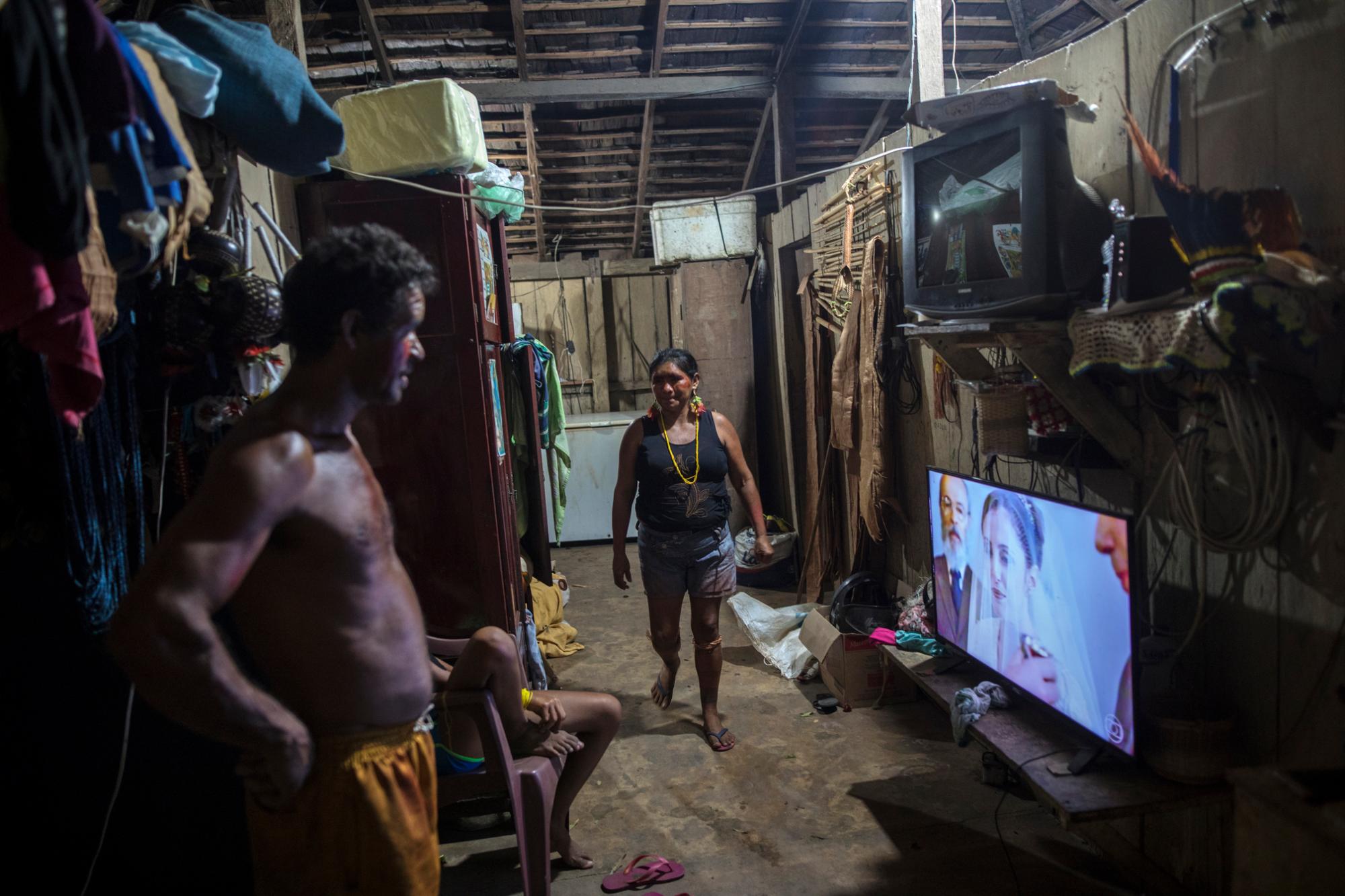 En esta imagen del 4 de septiembre de 2019, vecinos viendo una novela en su casa del poblado de Tekohaw, en el estado brasileño de Para, Brazil. Tradición y modernidad se cruzan en la vida cotidiana de los indígenas tembé en la Amazonía brasileña. 