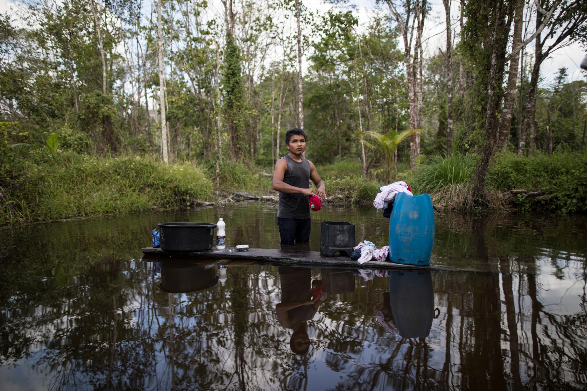 En esta imagen del 2 de septiembre de 2019, un joven lava su ropa en un lago en el poblado de Ka a kyr, en el estado brasileño de Para. Los pueblos a lo largo de los ríos Guama y Gurupo, que dividen la reserva, pueden tener desde unas docenas de personas a centenares. (AP Foto/Rodrigo Abd)