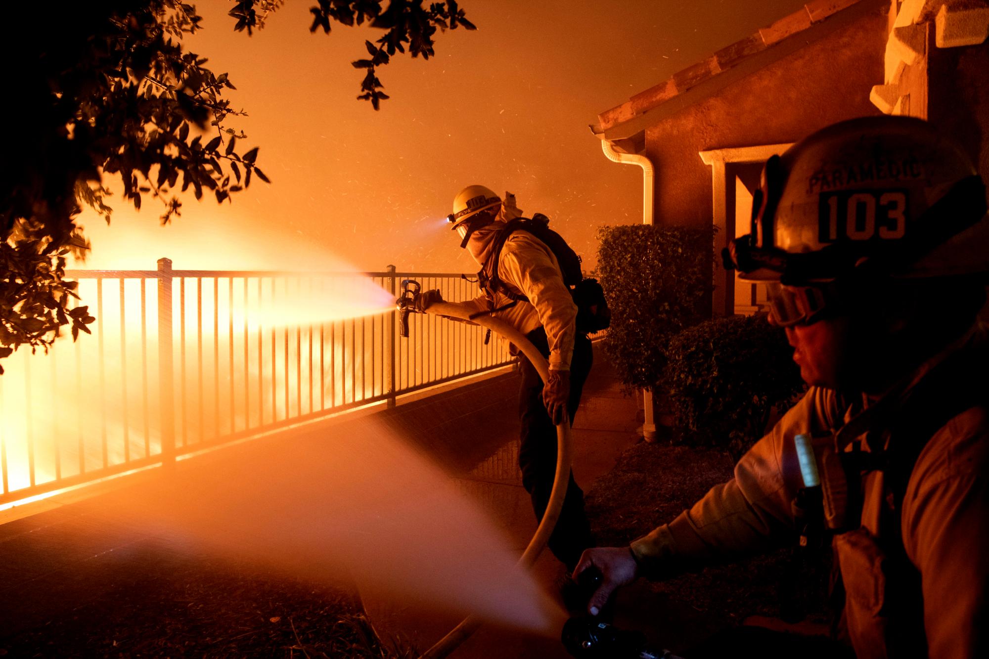 En esta foto del jueves 10 de octubre de 2019, los bomberos de la ciudad de Los Ángeles luchan contra el incendio de Saddleridge cerca de las casas en Sylmar, California 