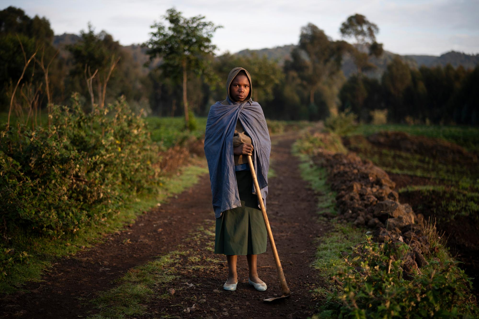 En esta foto del 5 de septiembre de 2019, la granjera Julienne de 13 años posa para una foto en Kinigi, Ruanda. En 2005, el gobierno adoptó un modelo para dirigir el 5% de los ingresos del turismo del Parque Nacional de los Volcanes para construir infraestructura en las aldeas circundantes, incluidas las escuelas y las clínicas de salud. Hace dos años, la participación se elevó al 10%. 