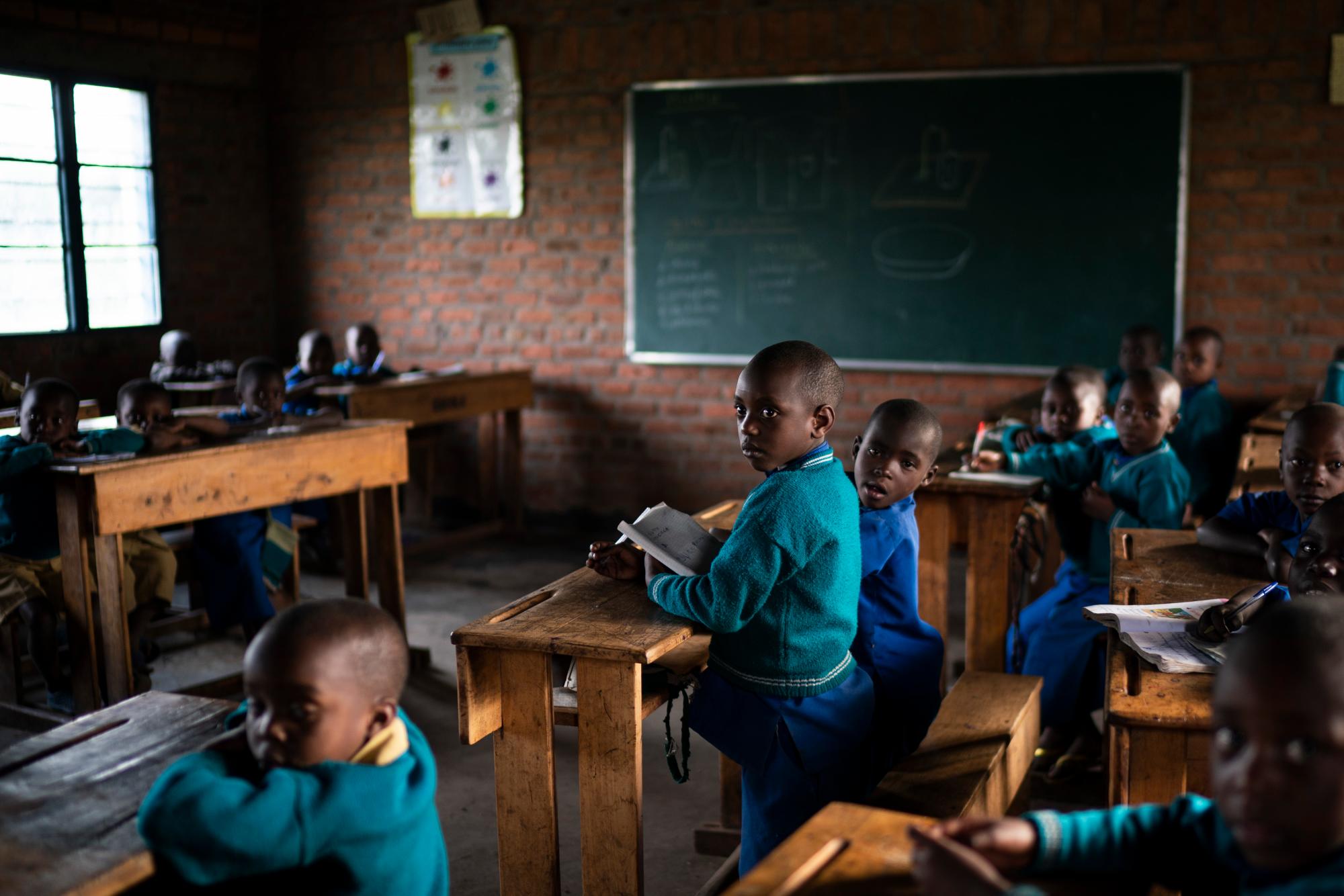 En esta foto del 5 de septiembre de 2019, los niños asisten a clases en la Escuela Primaria Nyabitsinde cerca del Parque Nacional de los Volcanes en Kinigi, Ruanda. “El dinero que construyó esta escuela proviene del turismo”, dice Fabien Uwimana, profesora de francés e inglés. “Más niños hoy pueden ir a la escuela”. 