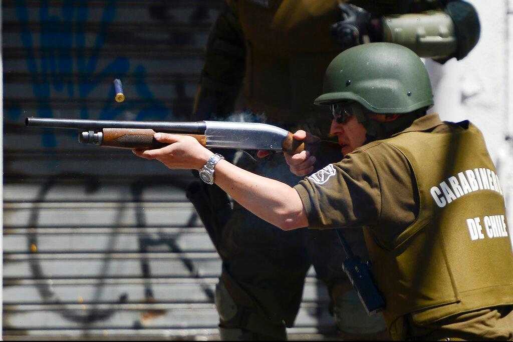 Un oficial de policía dispara una escopeta durante los enfrentamientos con manifestantes antigubernamentales en Valparaíso, Chile, el jueves 24 de octubre de 2019. 