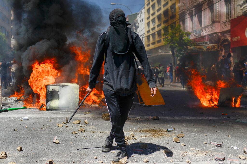 Un manifestante antigubernamental se encuentra frente a una barricada en llamas en Valparaíso, Chile, el jueves 24 de octubre de 2019.