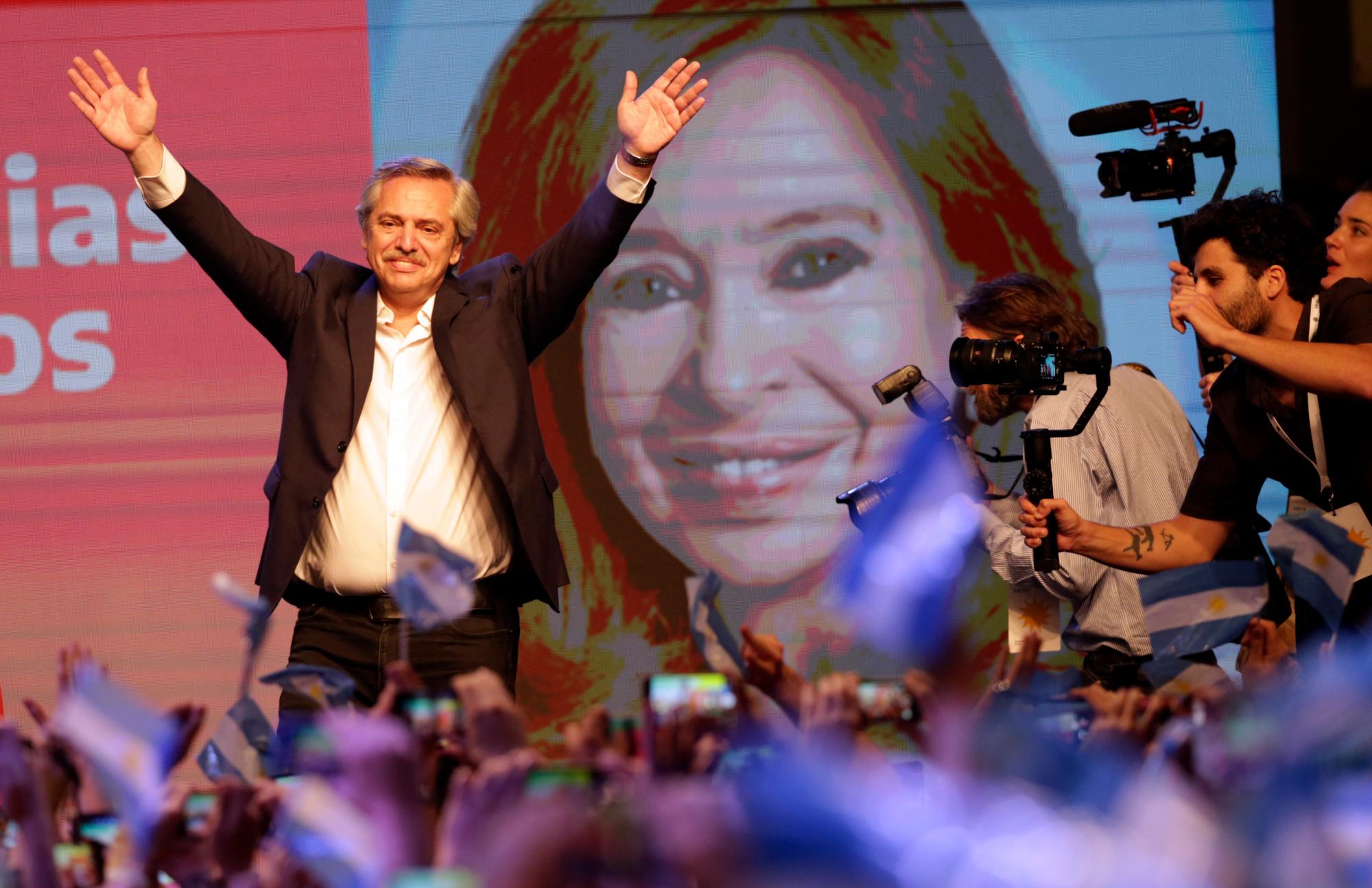 El candidato presidencial peronista Alberto Fernández saluda a los partidarios frente a una gran imagen de su compañero de fórmula, la ex presidenta Cristina Fernández, después de que el presidente en ejercicio Mauricio Macri admitiera la derrota al final del día de las elecciones en Buenos Aires, Argentina, el domingo 27 de octubre de 2019. El candidato presidencial peronista Alberto Fernández saluda a los partidarios frente a una gran imagen de su compañero de fórmula, la ex presidenta Cristina Fernández, después de que el presidente en ejercicio Mauricio Macri admitiera la derrota al final del día de las elecciones en Buenos Aires, Argentina, el domingo 27 de octubre de 2019.