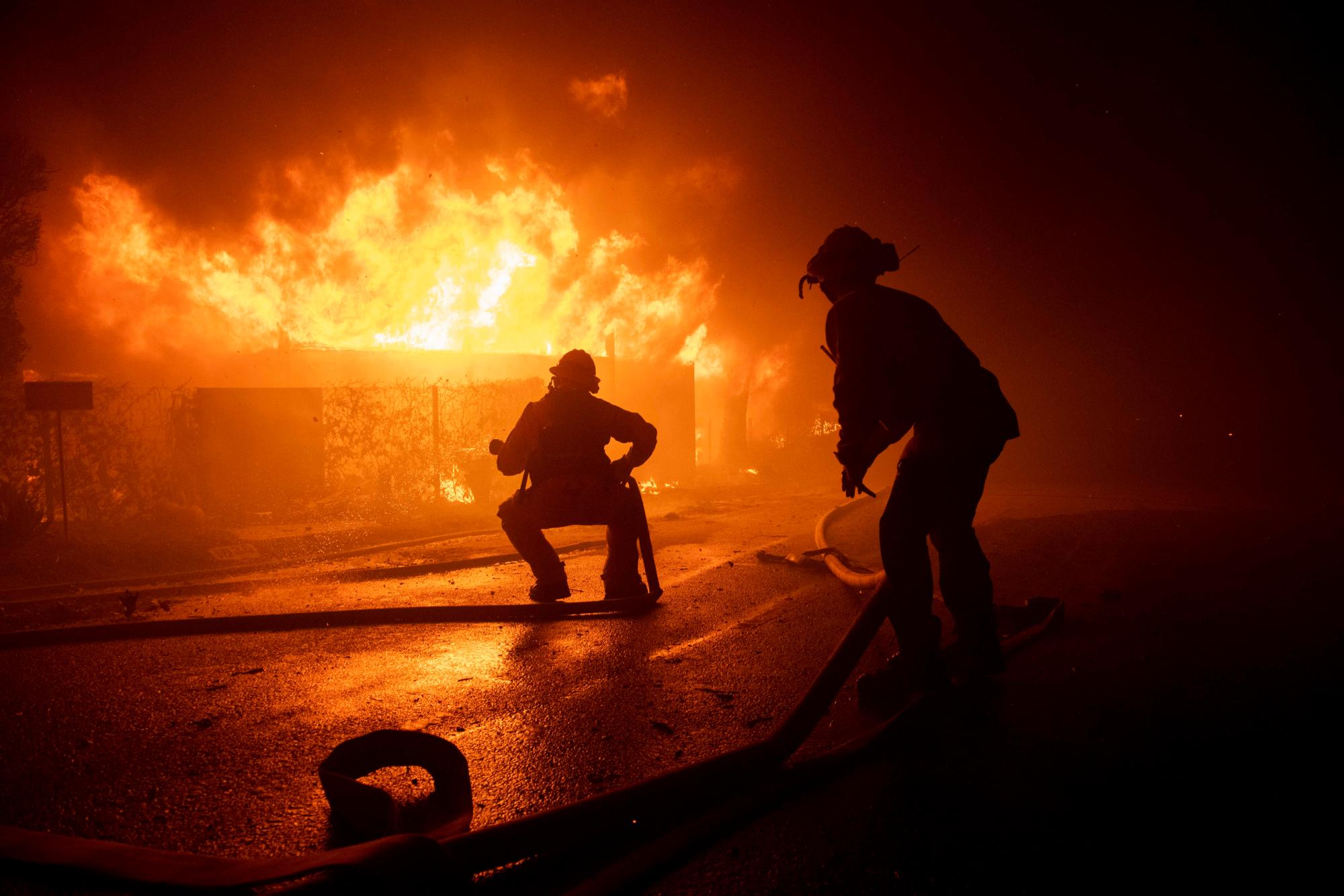 Firefighters try to save a home on Tigertail Road during the Getty fire, Monday, Oct. 28, 2019, in Los Angeles, Calif. 