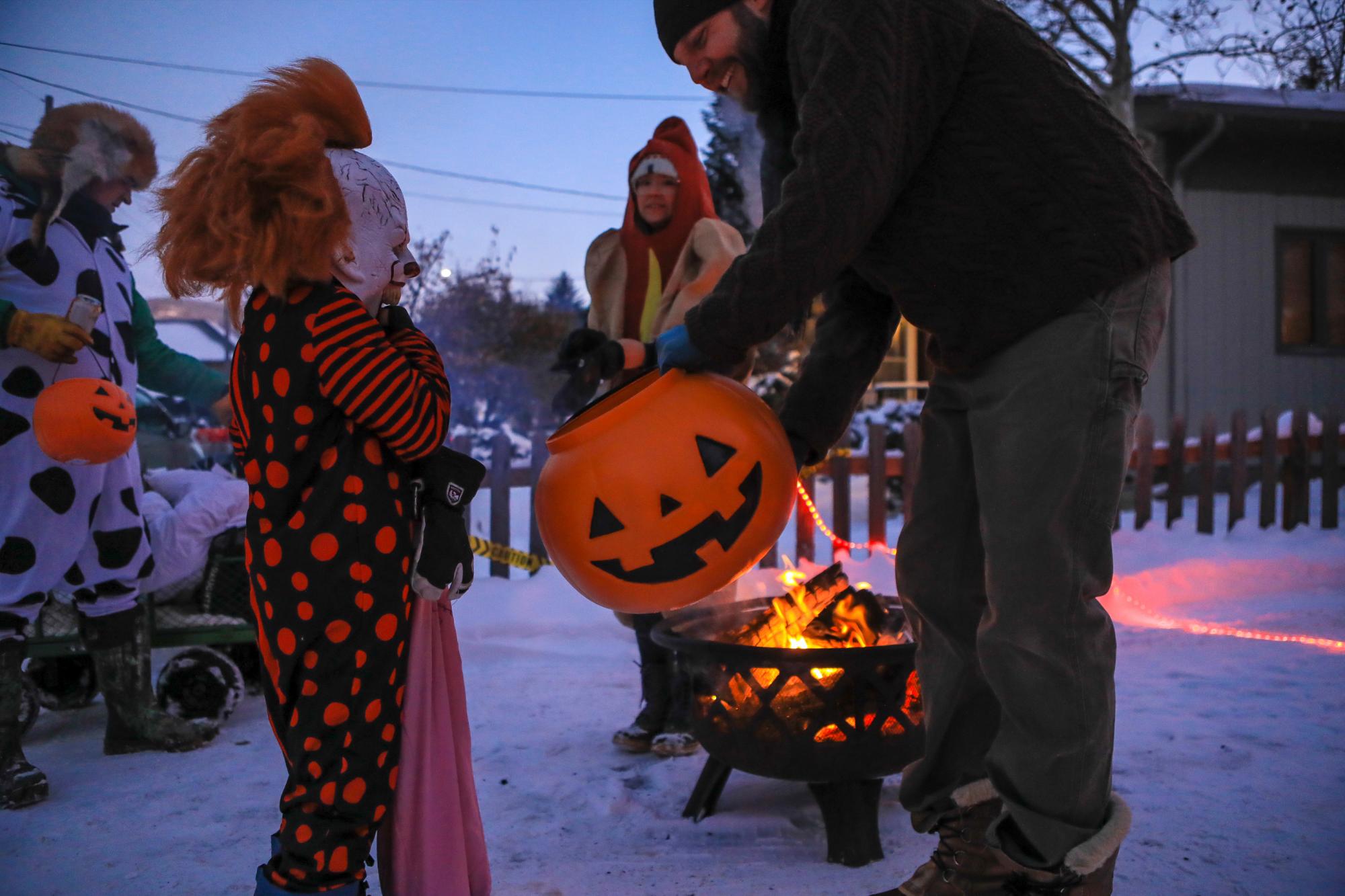 Greg Sparhawk reparte caramelos y proporciona un fuego cálido durante la noche de truco o trato anual de Minturn, Colorado, el miércoles 30 de octubre de 2019, en Minturn, Colorado. La temperatura rondaba un poco más de cero grados, por lo que probablemente sea uno de los más fríos.