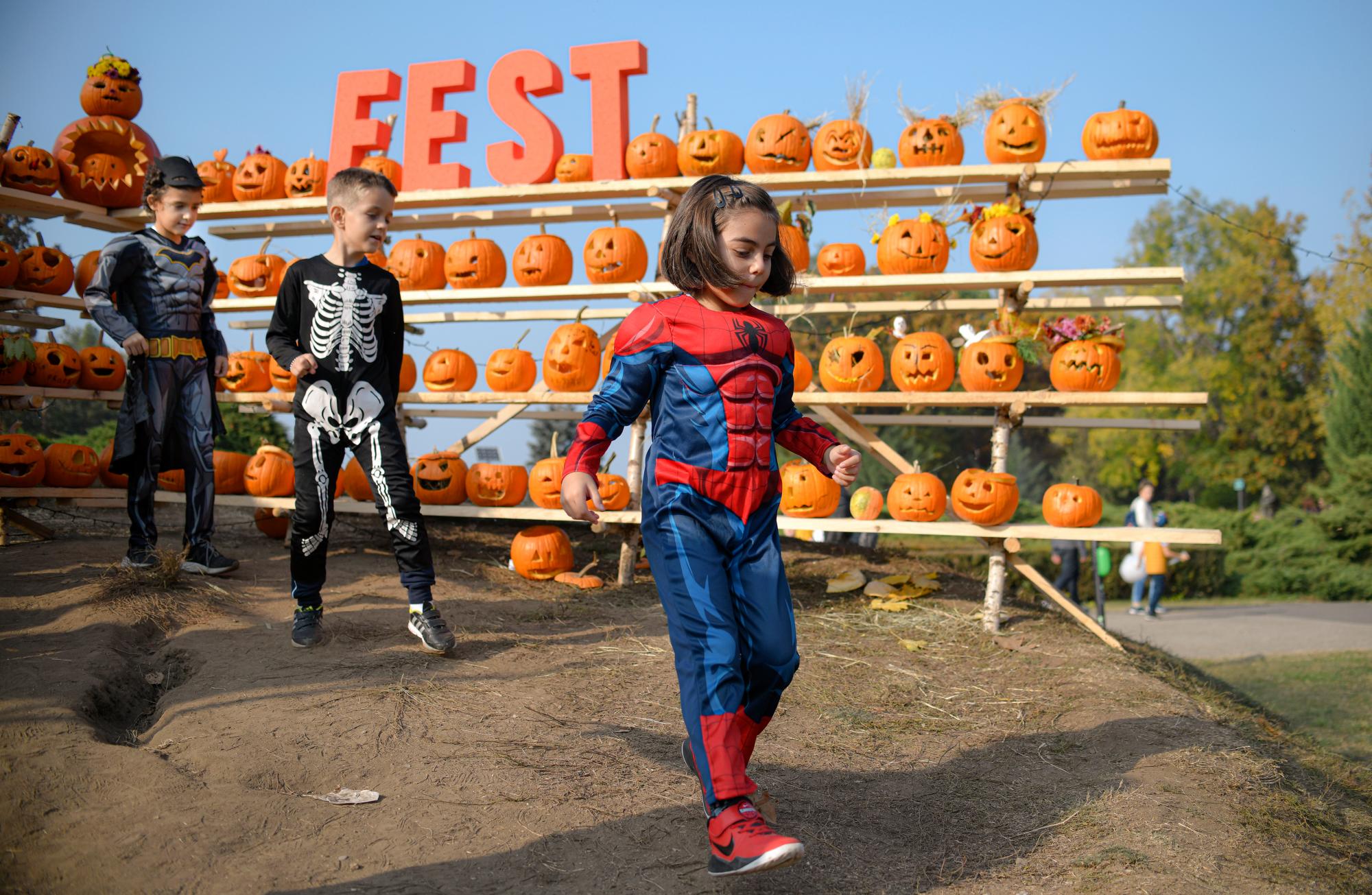En esta foto del sábado 26 de octubre de 2019, los niños vestidos con disfraces caminan junto a las calabazas de Halloween en el Halloween Pumpkin Fest en Bucarest, Rumania. 