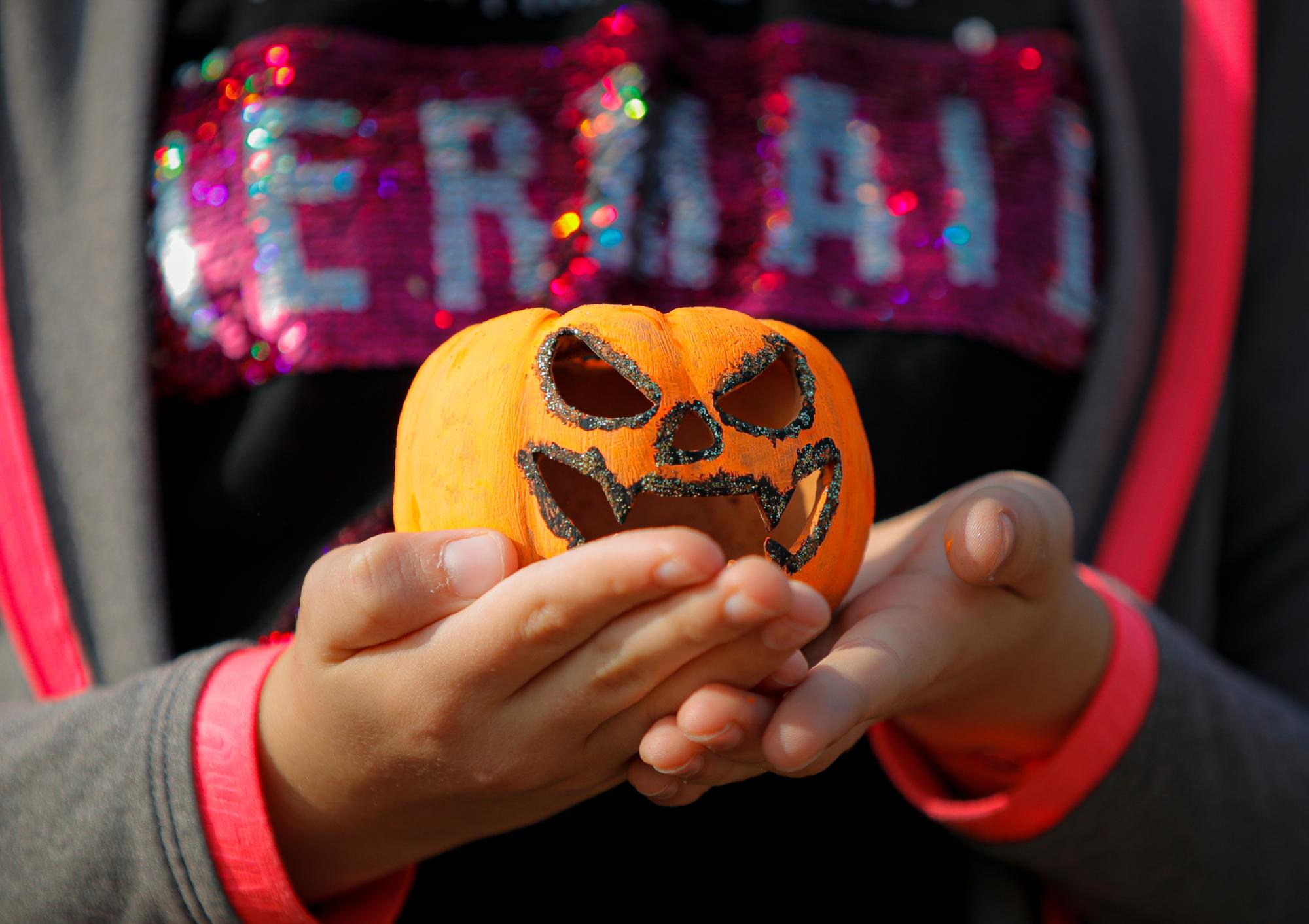 En esta foto del sábado 26 de octubre de 2019, un niño sostiene una calabaza tallada en el Halloween Pumpkin Fest en Bucarest, Rumania. 