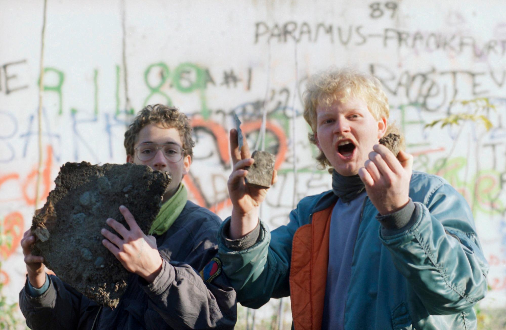 ARCHIVO - En esta foto de archivo del 10 de noviembre de 1989, los escolares de Berlín muestran con orgullo los ladrillos del Muro de Berlín que encontraron cerca de la Puerta de Brandenburgo en Berlín.