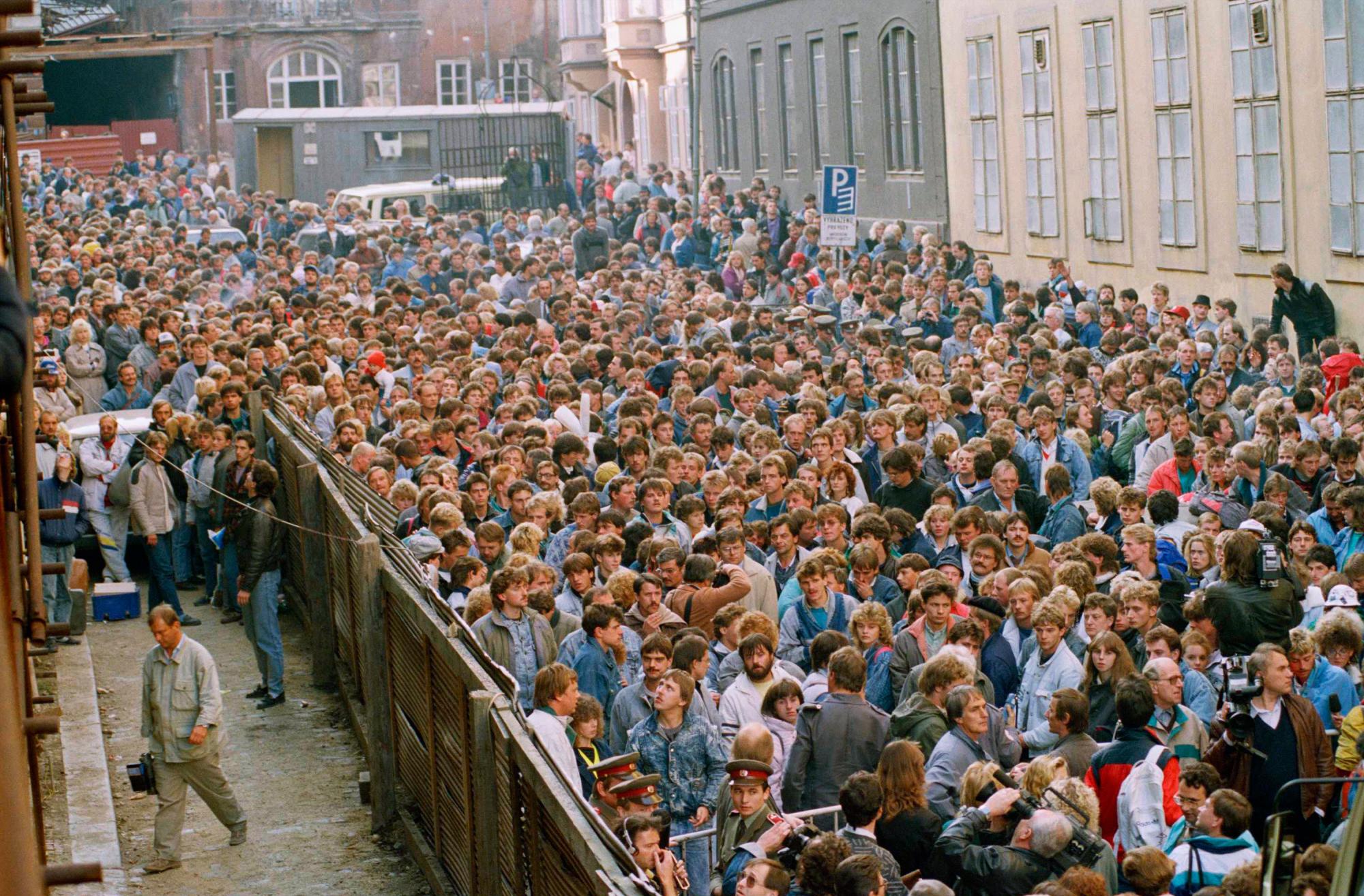 ARCHIVO - En esta foto de archivo del miércoles 4 de octubre de 1989, una multitud de alrededor de 10,000 refugiados de Alemania Oriental se agolpan en la calle frente a la embajada de Alemania Occidental en Praga, República Checa, antes de que se les permita abordar autobuses para llevarlos a trenes especiales con destino a Alemania Occidental. 
