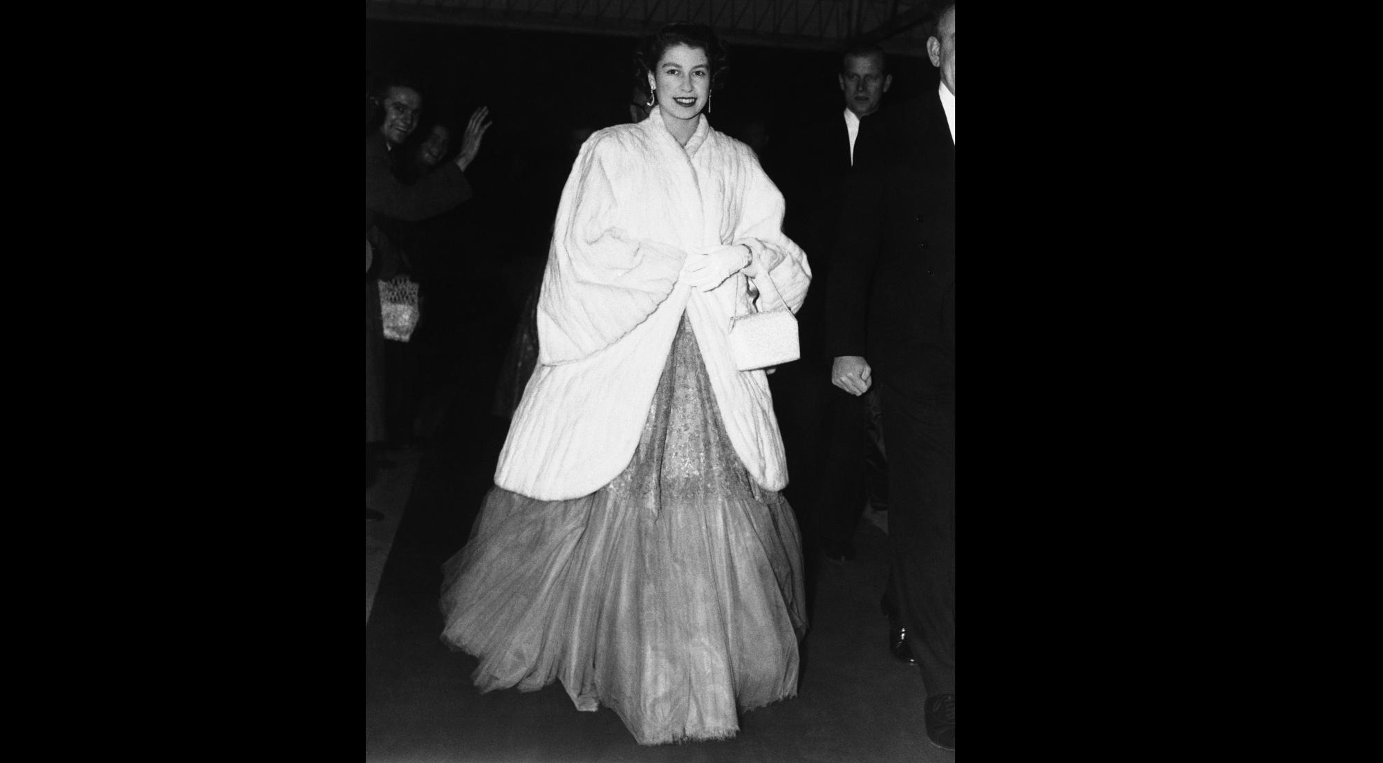 En esta foto del 28 de noviembre de 1952, la reina Isabel II de Inglaterra, con un abrigo de piel sobre un vestido de gala, llega al concierto del Día de Santa Cecilia en el Royal Festival Hall en Londres.