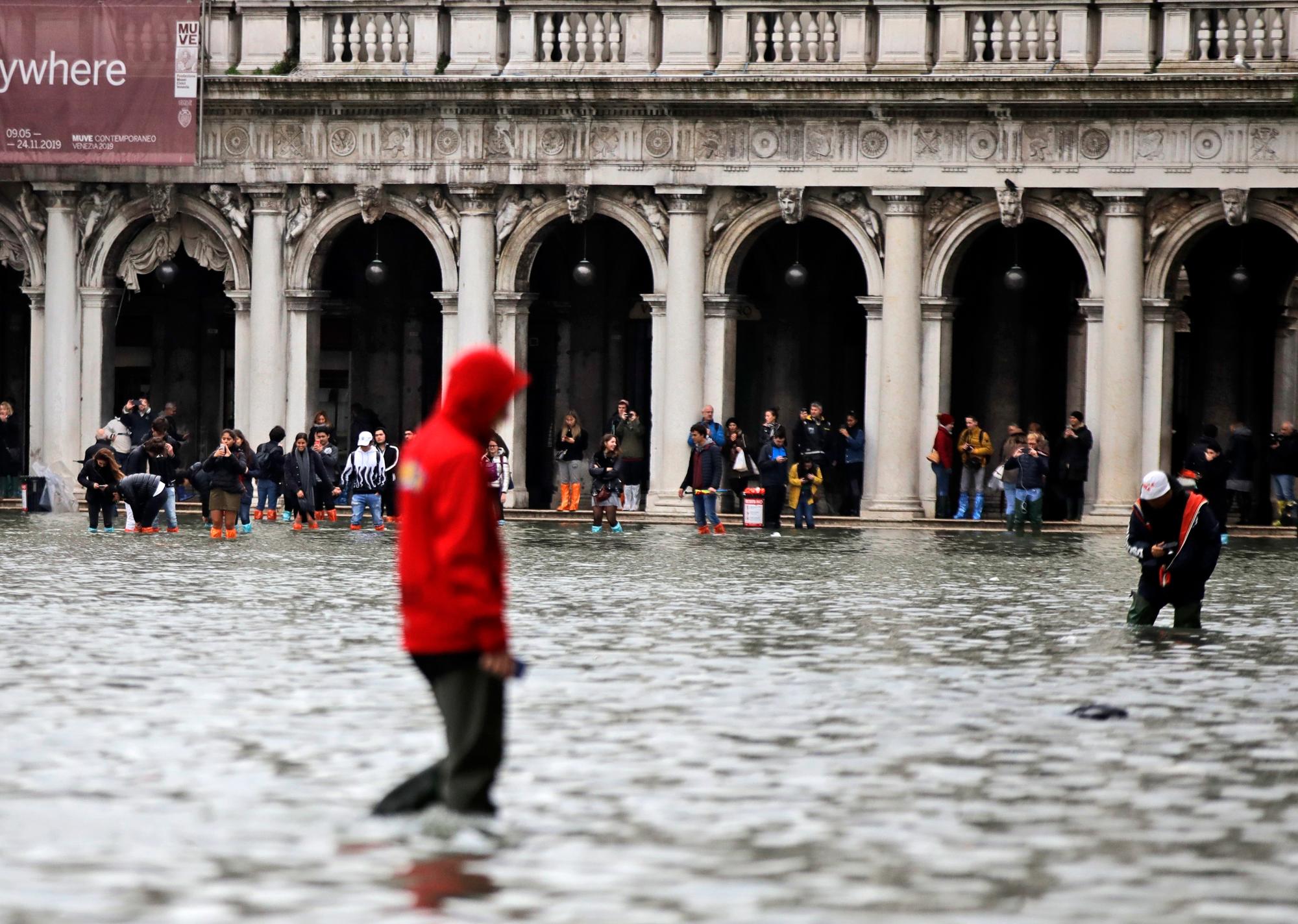 La gente vadea por el agua en la Plaza de San Marcos, en Venecia, el miércoles 13 de noviembre de 2019. La marca de marea alta golpeó 187 centímetros (74 pulgadas) el martes 12 de noviembre de 2019, lo que significa más del 85% de la ciudad. fue inundado El nivel más alto jamás registrado fue de 194 centímetros (76 pulgadas) durante las inundaciones infames en 1966. 