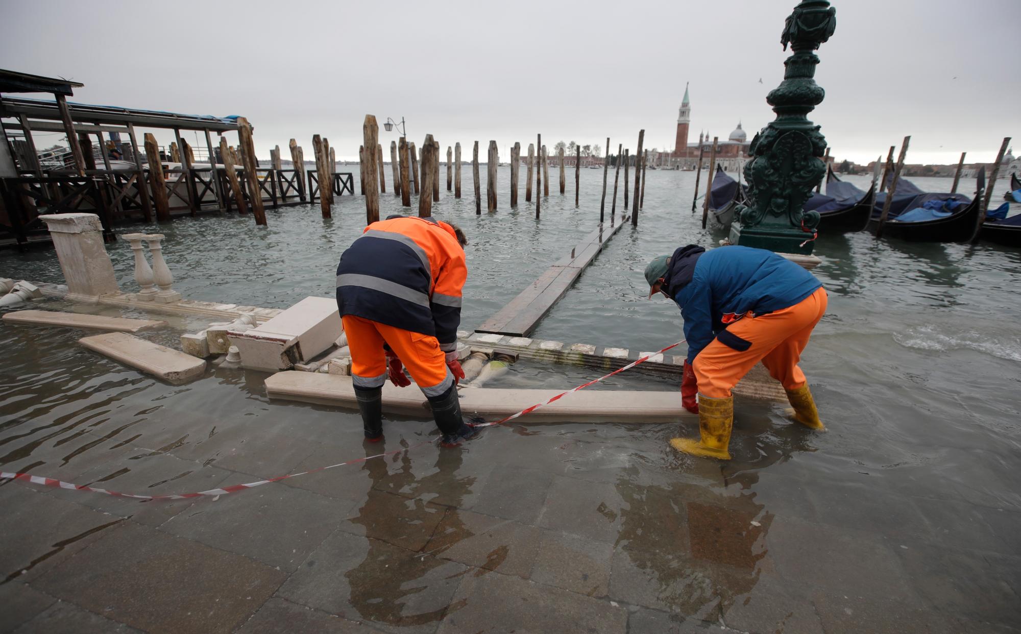 Los trabajadores evalúan el daño en un muelle, en Venecia, el miércoles 13 de noviembre de 2019. La marca de marea alta golpeó 187 centímetros (74 pulgadas) el martes 12 de noviembre de 2019, lo que significa que más del 85% de la ciudad se inundó . El nivel más alto jamás registrado fue de 194 centímetros (76 pulgadas) durante las inundaciones infames en 1966. 
