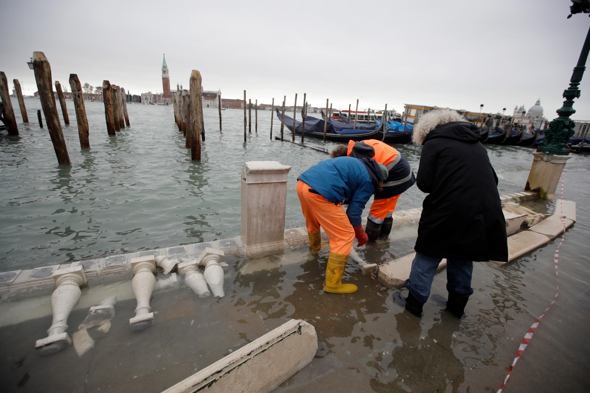 Los trabajadores evalúan el daño en un muelle, en Venecia, el miércoles 13 de noviembre de 2019. La marca de marea alta golpeó 187 centímetros (74 pulgadas) el martes 12 de noviembre de 2019, lo que significa que más del 85% de la ciudad se inundó . El nivel más alto jamás registrado fue de 194 centímetros (76 pulgadas) durante las inundaciones infames en 1966. 