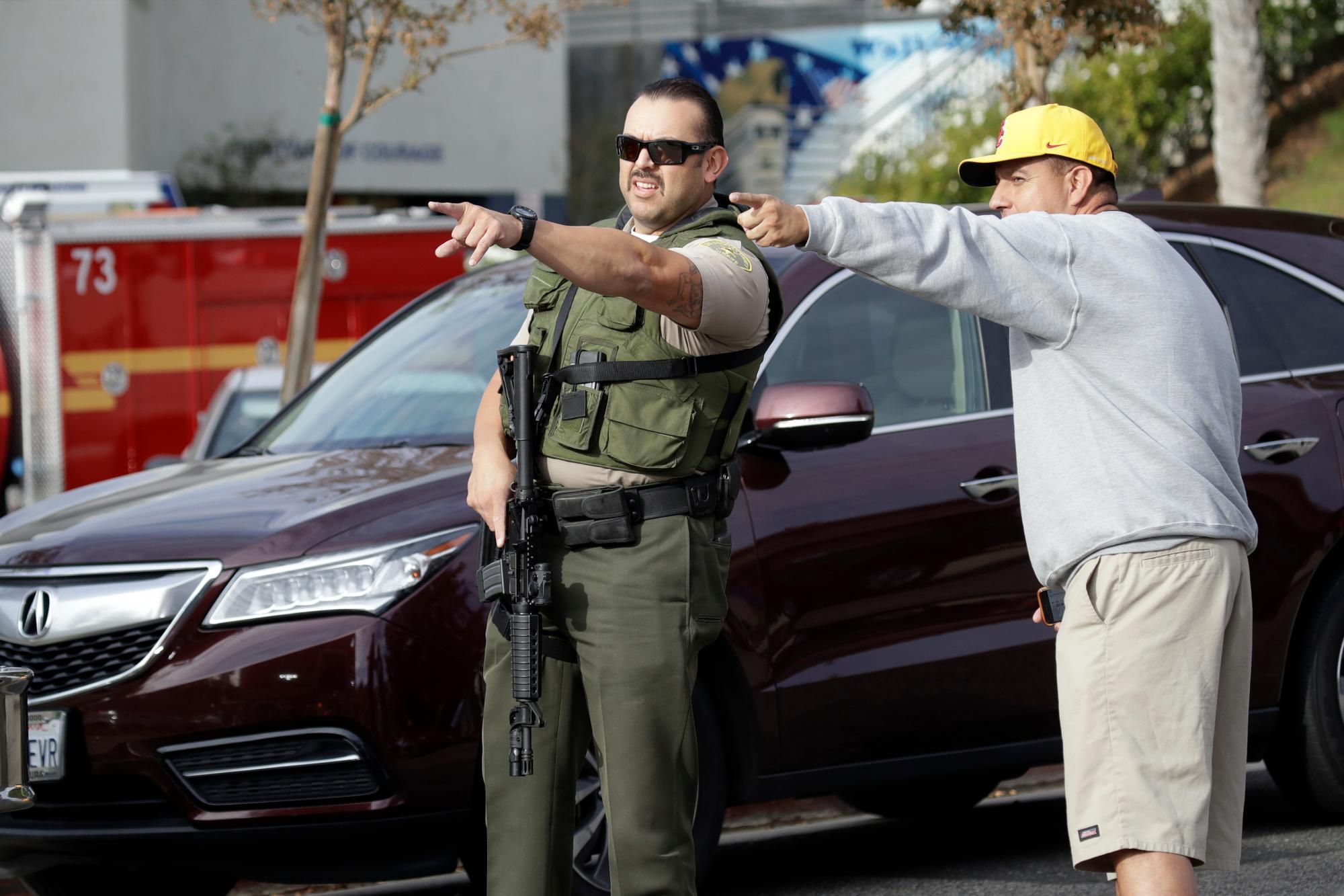 Un miembro del Departamento del Sheriff del Condado de Los Ángeles señala al lado de un espectador fuera de la Escuela Secundaria Saugus después de los informes de un tiroteo el jueves 14 de noviembre de 2019 en Santa Clarita, California 