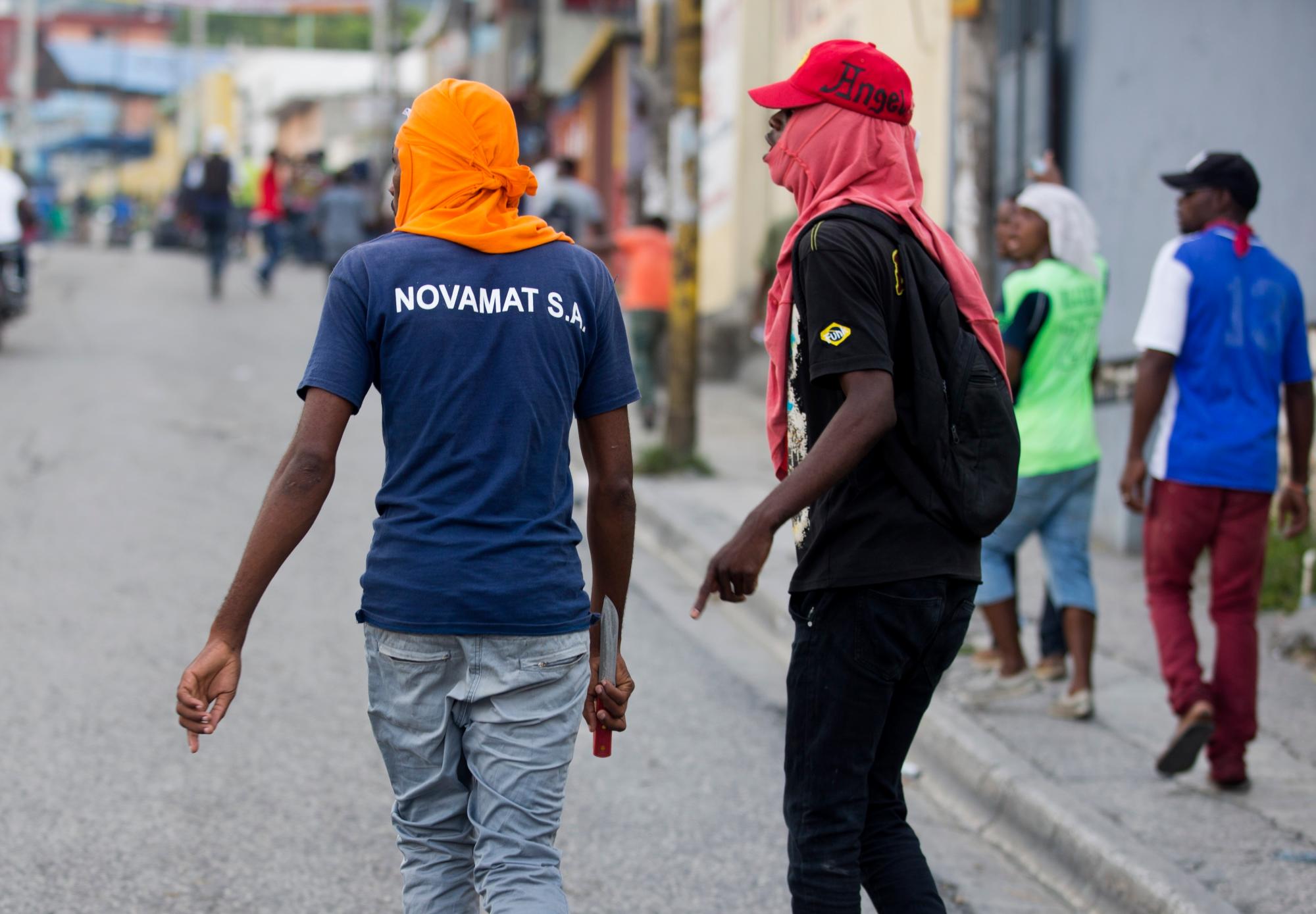 Un manifestante camina con un cuchillo en la mano durante una protesta para exigir la renuncia del presidente de Haití, Jovenel Moise, en el 216 aniversario de la Batalla de Vertieres en Puerto Príncipe, Haití, el lunes 18 de noviembre de 2019. Al menos cuatro personas. fueron baleados y heridos durante una pequeña protesta en la capital de Haití luego de un discurso del presidente Moise. Un periodista local, un oficial de policía y dos manifestantes fueron trasladados rápidamente con heridas de bala aparentes. 