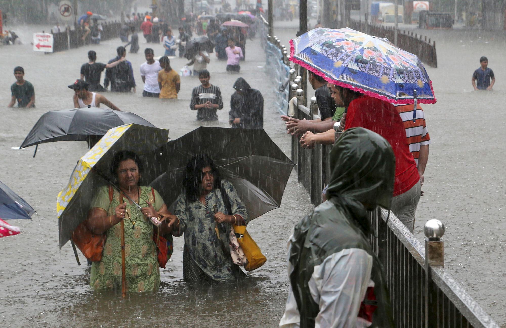 La gente navega por una calle inundada por lluvias torrenciales en Mumbai, India, el 4 de septiembre de 2019. 