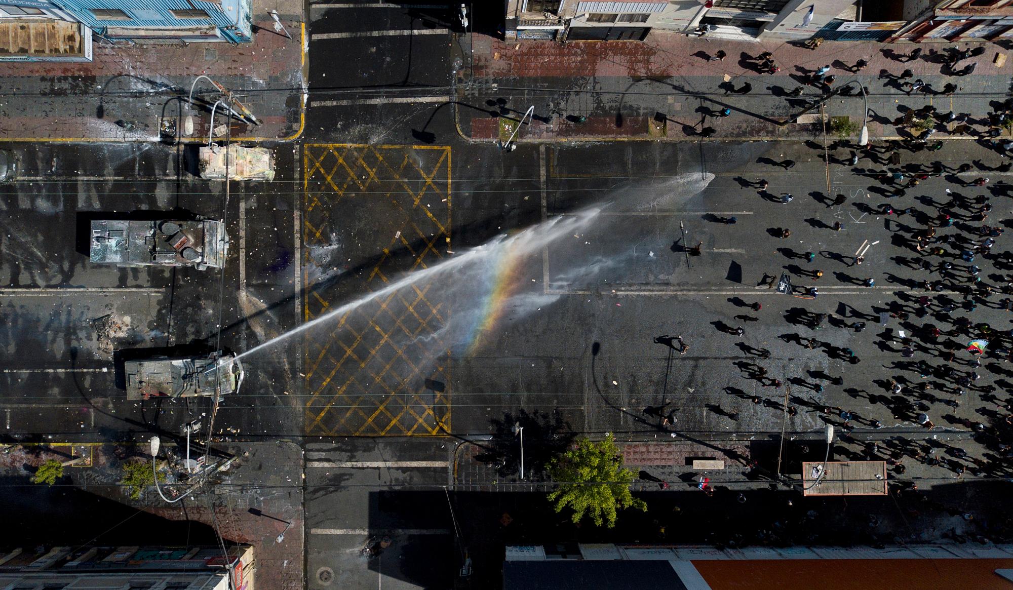 Un cañón de agua de la policía rocía manifestantes antigubernamentales en Valparaíso, Chile, el 26 de octubre de 2019.