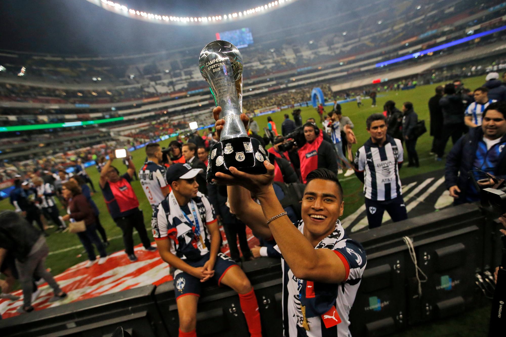 En esta imagen, tomada el 29 de diciembre de 2019, un futbolista del Monterrey sostiene el trofeo de campeón de la liga mexicana tras derrotar al América 4-2 en la tanda de penales, en el Estadio Azteca, en la Ciudad de México. (AP Foto/Eduardo Verdugo)