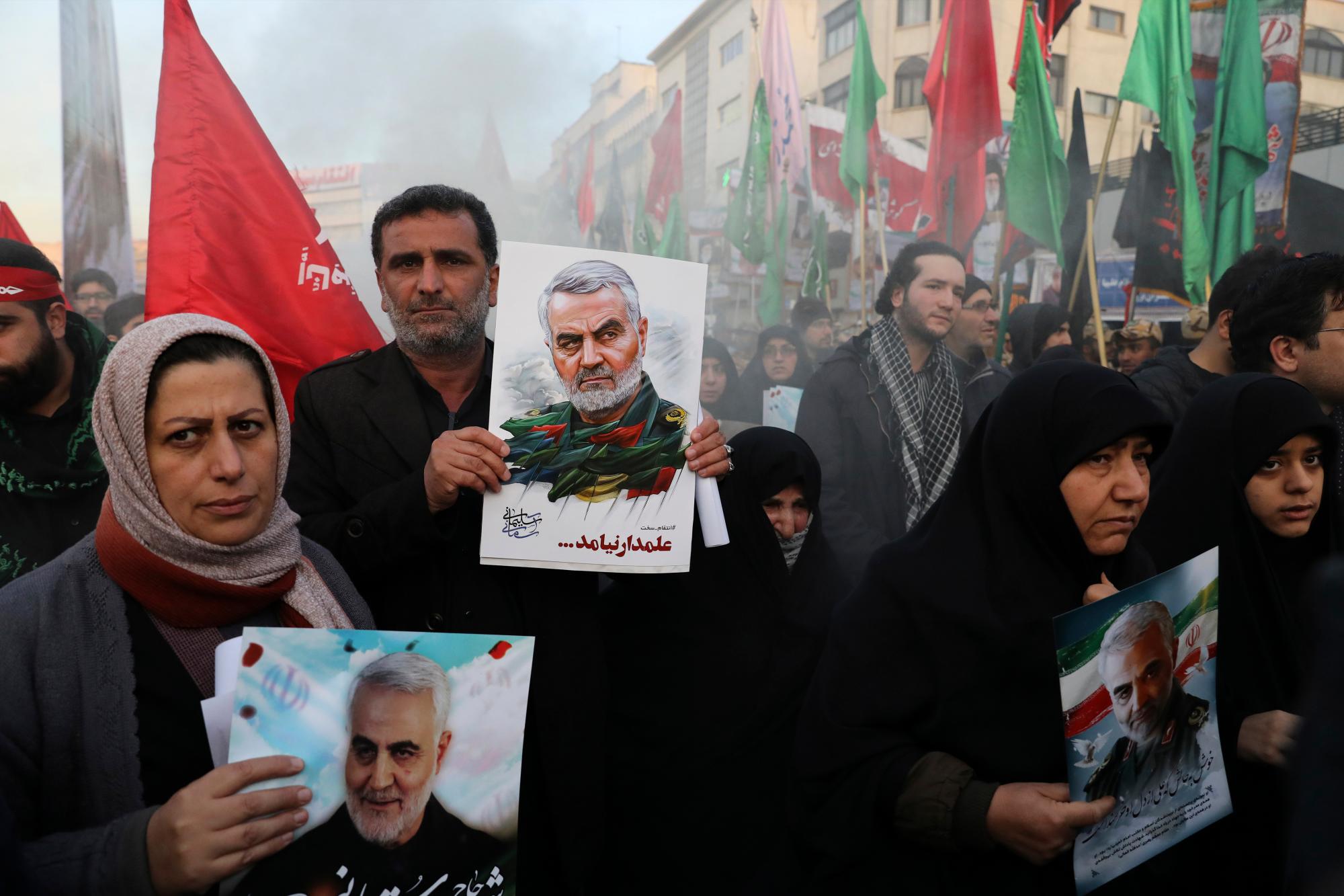 Los dolientes con carteles del general iraní Qassem Soleimani asisten a una ceremonia fúnebre para él y sus camaradas, que fueron asesinados en Irak en un ataque con aviones no tripulados de Estados Unidos el viernes, en la Plaza Enqelab-e-Eslami (Revolución Islámica) en Teherán, Irán, el lunes , 6 de enero de 2020. (Foto AP / Ebrahim Noroozi)