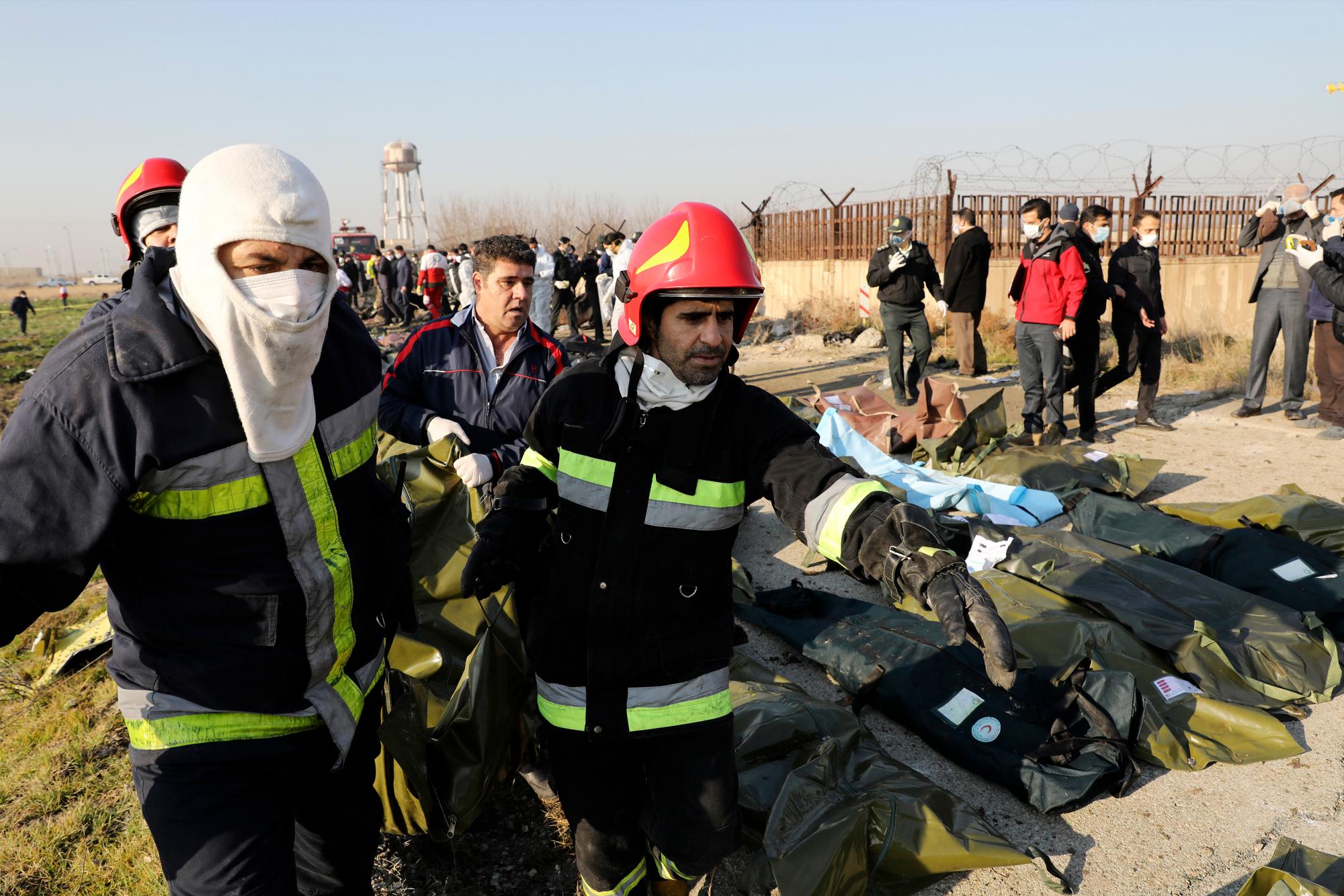 Los equipos de rescate llevan el cuerpo de una víctima de un accidente de avión ucraniano en Shahedshahr, suroeste de la capital, Teherán, Irán, el miércoles 8 de enero de 2020. Un avión ucraniano que transportaba a 176 personas se estrelló el miércoles poco después del despegue del aeropuerto principal de Teherán, matando todos a bordo. 