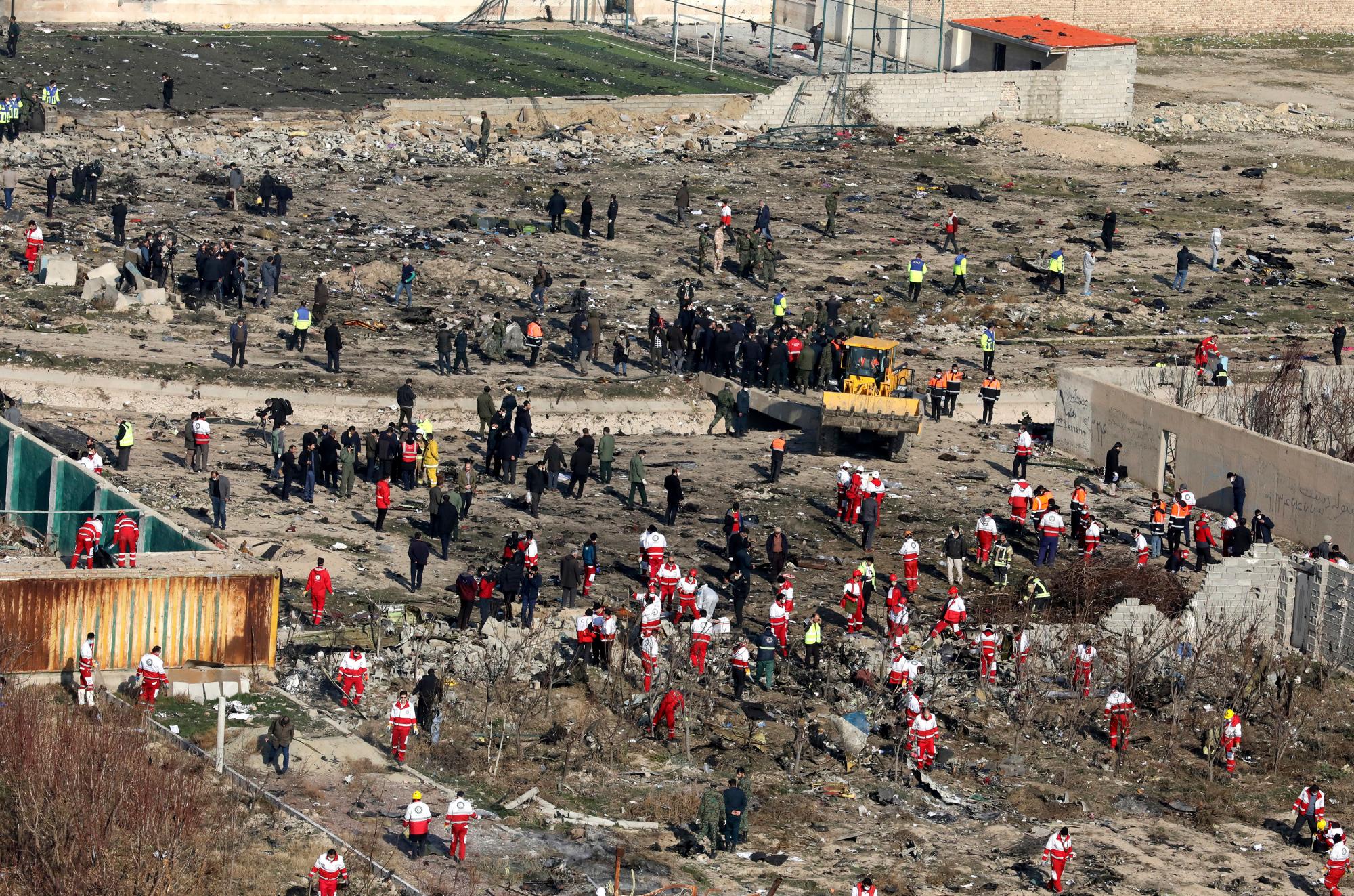 Los equipos de rescate buscan en la escena donde un avión ucraniano se estrelló en Shahedshahr, al suroeste de la capital, Teherán, Irán, el miércoles 8 de enero de 2020. Un avión de pasajeros ucraniano que transportaba a 176 personas se estrelló el miércoles, pocos minutos después de despegar de la capital de Irán. aeropuerto, convirtiendo tierras de cultivo en las afueras de Teherán en campos de escombros en llamas y matando a todos a bordo. 