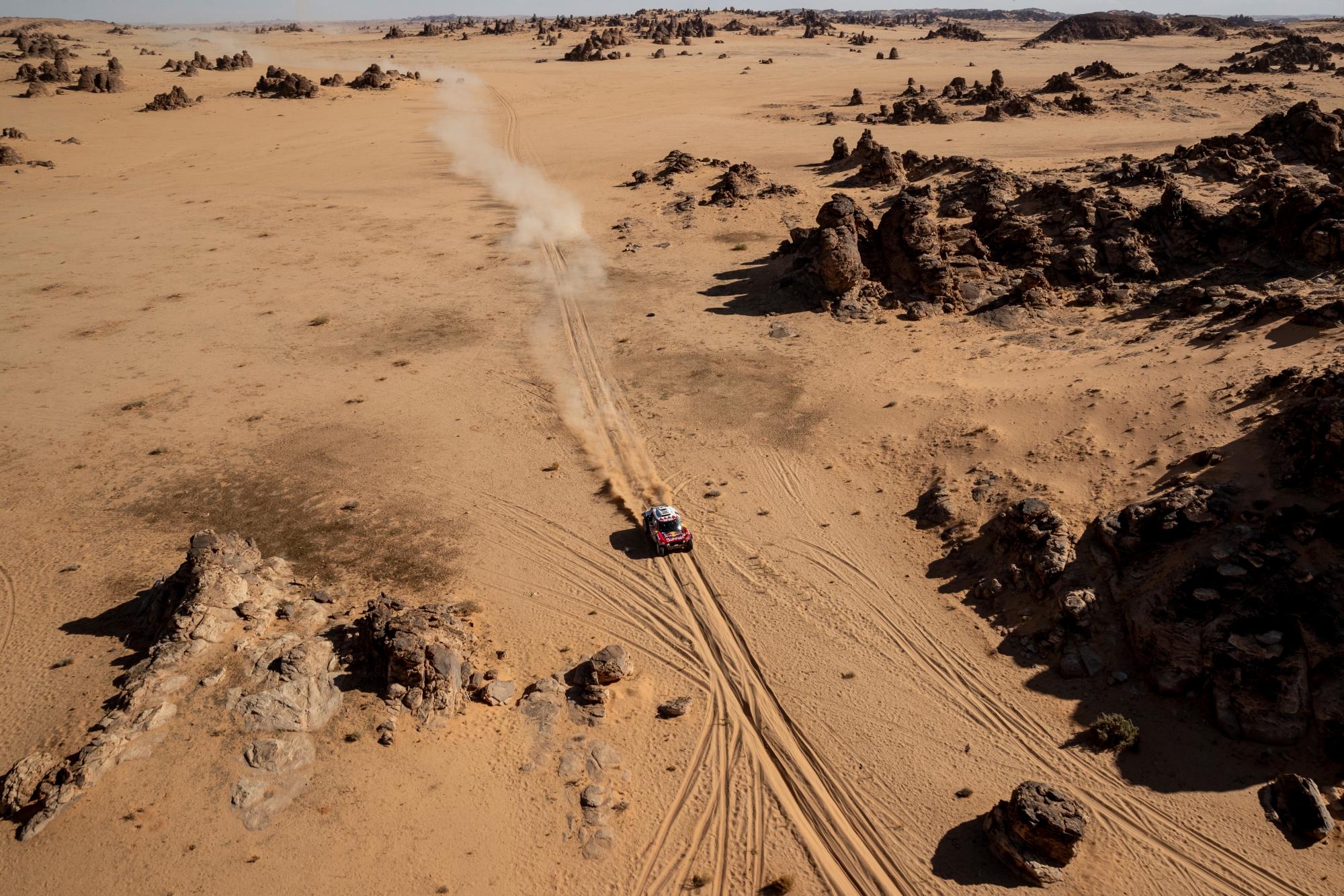 Driver Carlos Sainz, of Spain, and co-driver Lucas Cruz, of Spain, race their Mini during stage four of the Dakar Rally between Neom and Al Ula, in Saudi Arabia, Wednesday, Jan. 8, 2020. 