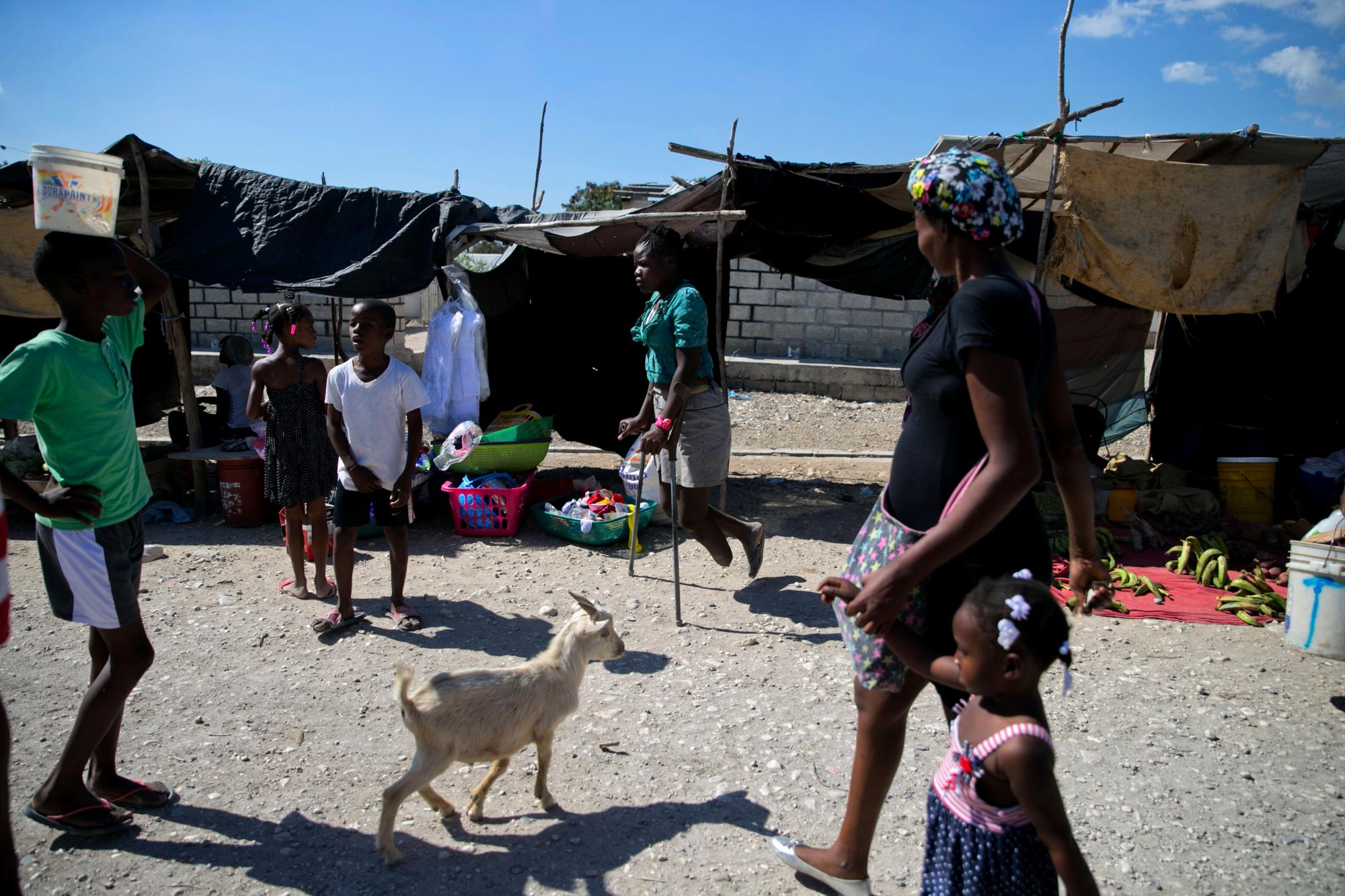 En esta foto del 3 de enero de 2020, Rose-Berline Thomas camina con muletas a través de un mercado en Canaan, un distrito en Croix des Bouquets, Haití, creado para las personas que perdieron sus hogares en el terremoto hace 10 años. Rose-Berline, quien perdió su pie cuando tenía 2 años durante un terremoto masivo que derrumbó su casa encima de ella, dice que su sueño es convertirse en enfermera. 