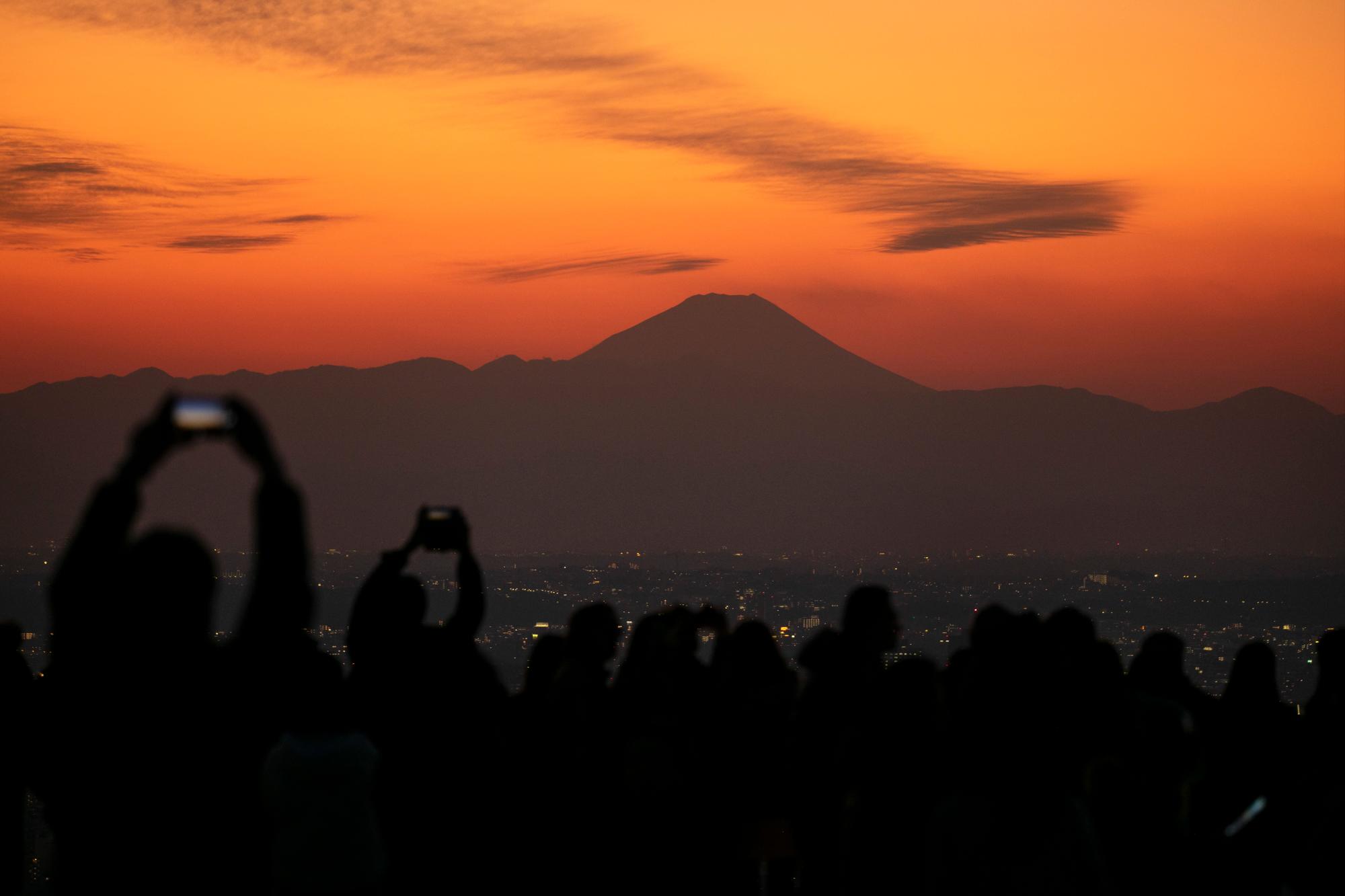 Los visitantes toman fotos del monte Fuji desde la plataforma de observación del cielo de Shibuya el lunes 20 de enero de 2020, en el distrito de Shibuya de Tokio. Ubicado en la azotea de Shibuya Scramble Square, un rascacielos de 47 pisos, el observatorio es la plataforma de observación al aire libre más nueva de Tokio, con vistas al famoso cruce de Shibuya. 