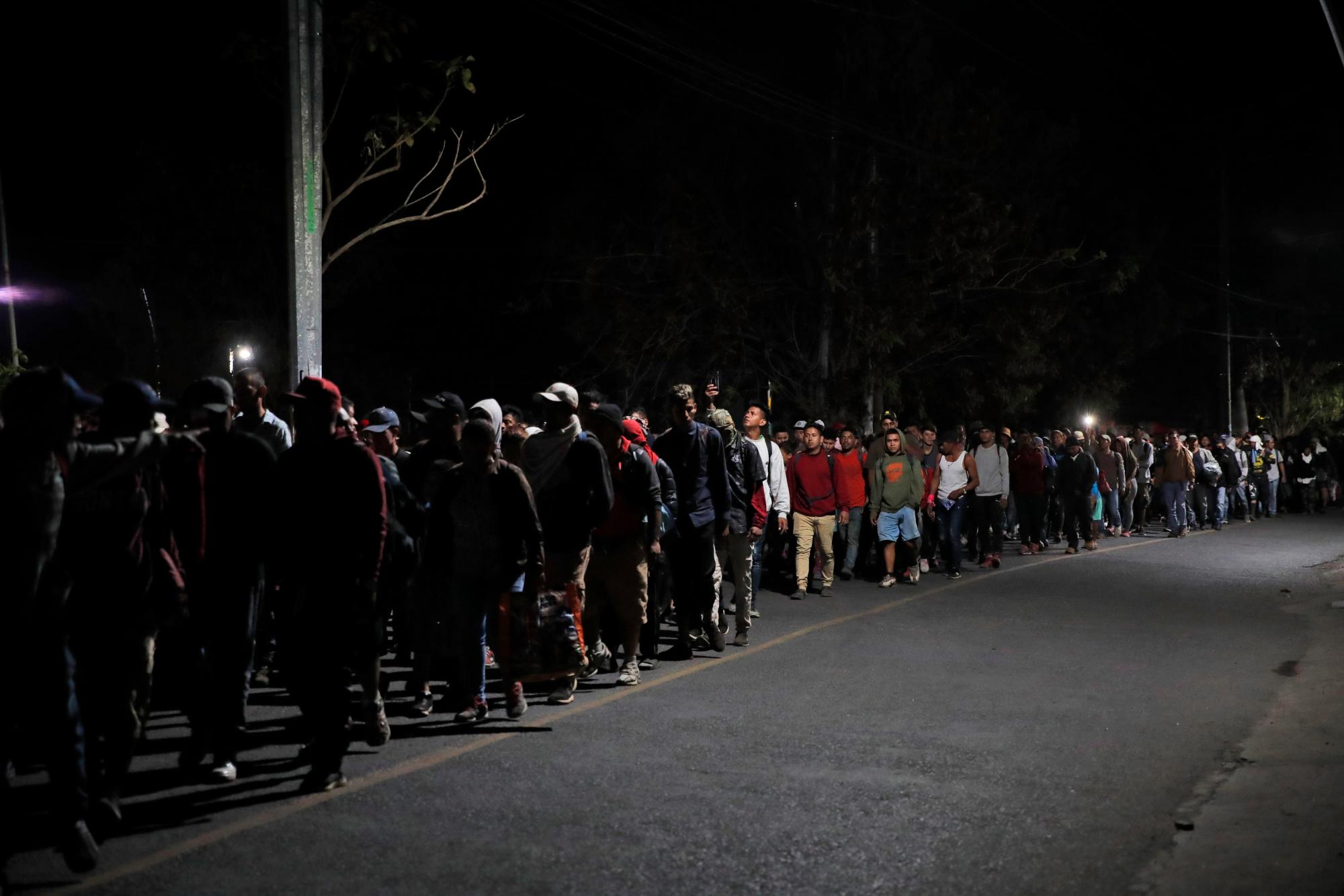 En esta imagen, tomada el 23 de enero de 2020, migrantes centroamericanos salen de Tecún Umán, Guatemala, caminando antes del amanecer para cruzar el río Suchiate e ingresar a México. Los migrantes, que esperan llegar a Estados Unidos, vadearon el río en masa en un intento de convencer a las autoridades mexicanas de que permitan su avance por el país. (AP Foto/Moisés Castillo)