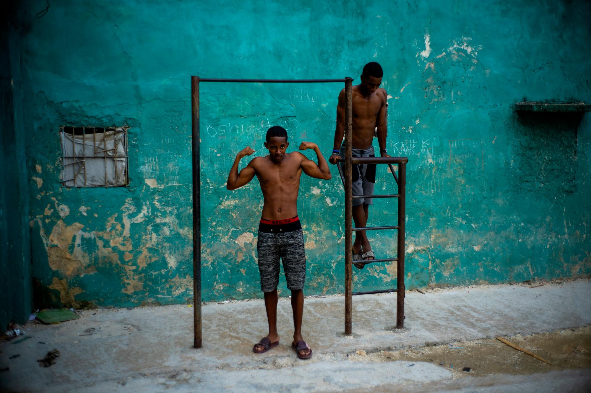 En la imagen, tomada el 5 de febrero de 2020, un joven posa mostrando sus músculos bajo una barra de ejercicios, en La Habana, Cuba.