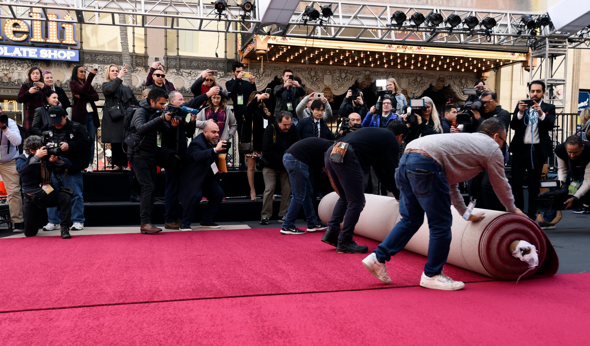 Fotógrafos toman fotos de trabajadores que desenrrollan la alfombra roja para los premios Oscar del domingo en el Teatro Dolby, el miércoles 5 de febrero del 2020 en Los Angeles.