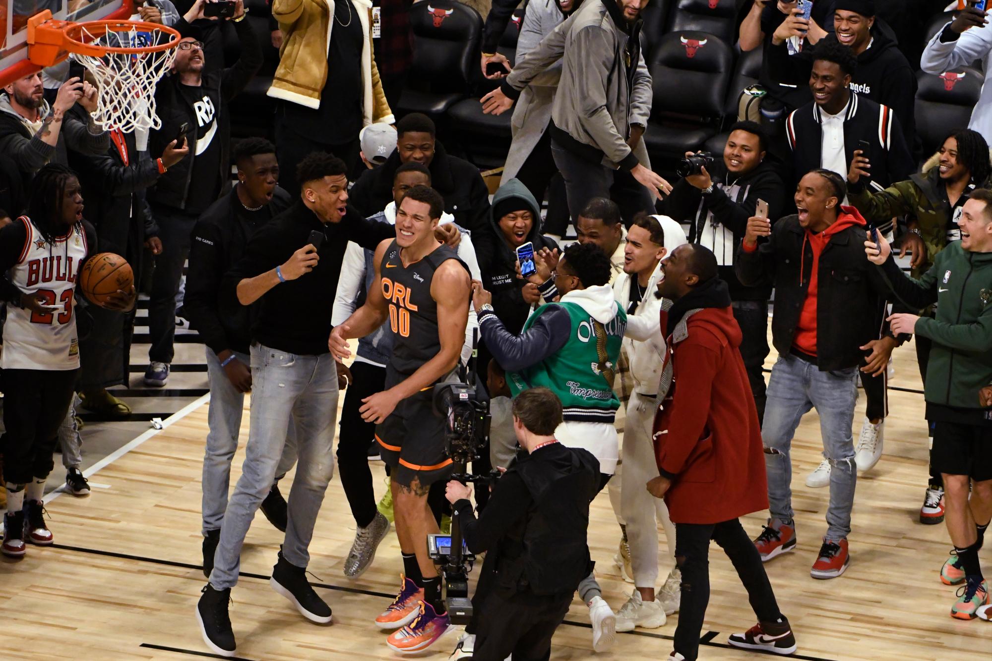 La gente se reúne alrededor de Aaron Gordon, de Orlando Magic, durante el concurso de baloncesto de la NBA All-Star slam dunk el sábado 15 de febrero de 2020 en Chicago. 