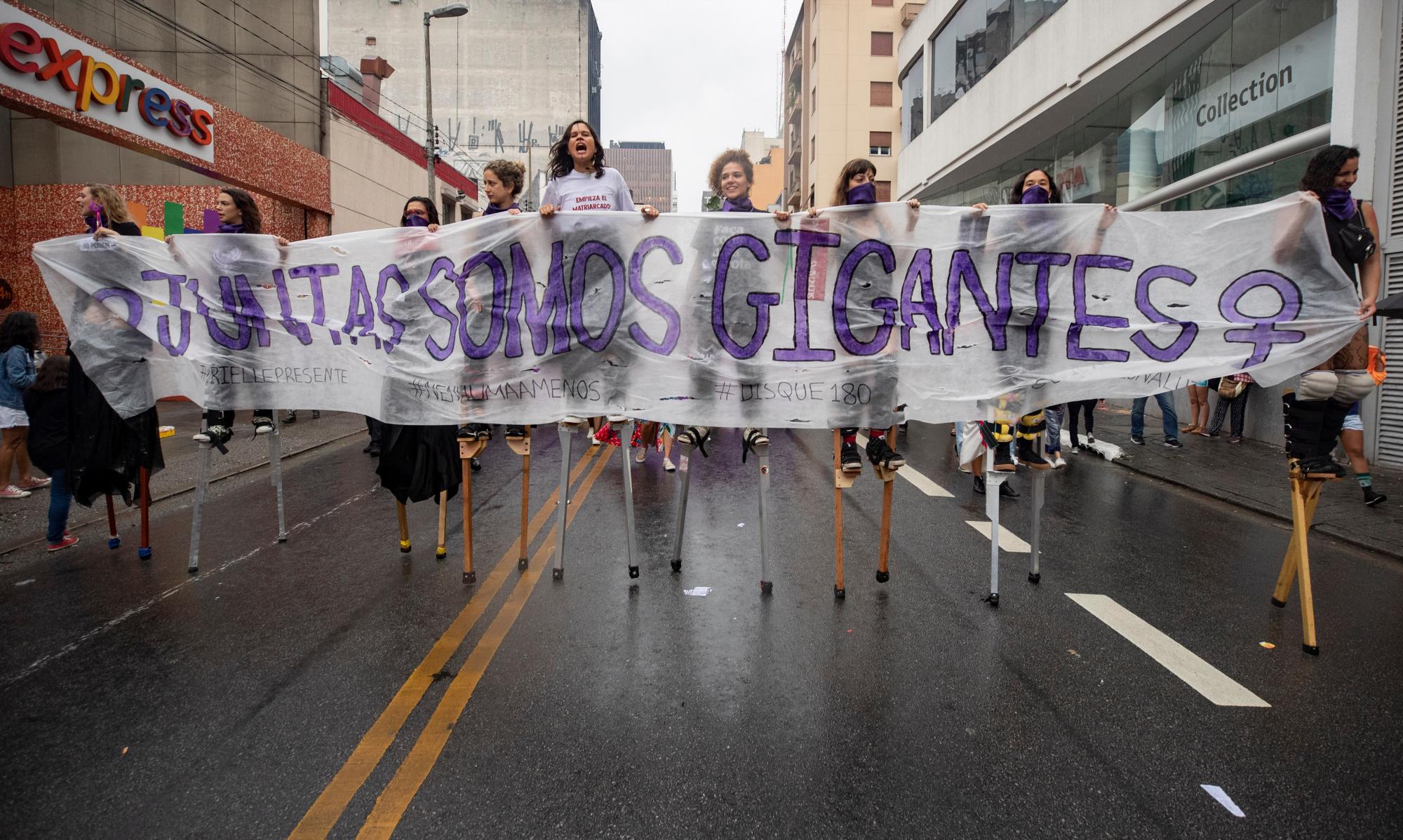 Las mujeres marchan gritando consignas contra el presidente de Brasil, Jair Bolsonaro, y sosteniendo una pancarta que dice en portugués “Juntos somos gigantes” para conmemorar el Día Internacional de la Mujer en Sao Paulo, Brasil, el domingo 8 de marzo de 2020.