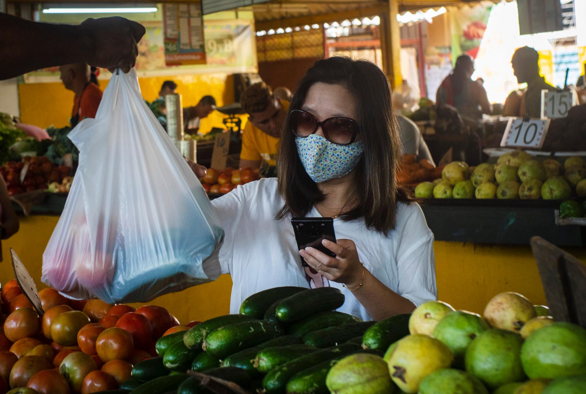 Una mujer, que usa una máscara protectora como precaución contra la propagación del nuevo coronavirus, compra vegetales en un mercado en La Habana, Cuba, el martes 17 de marzo de 2020. La gran mayoría de las personas se recuperan del nuevo virus. 
