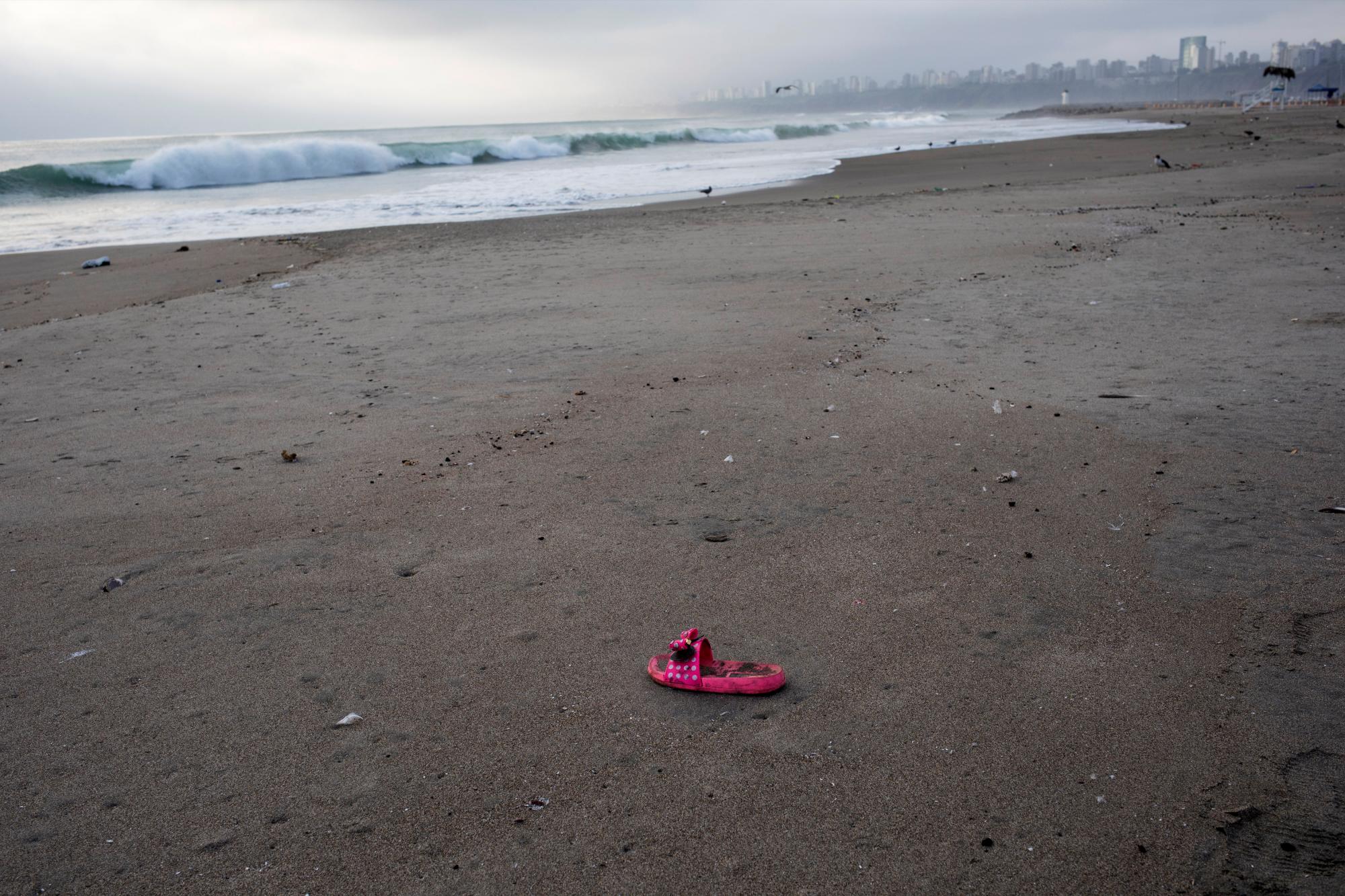 En esta imagen, tomada el 25 de marzo de 2020, una sandalia abandonada en la orilla de la playa de Agua Dulce, que suele estar atestada de bañistas en esta época del año, en Lima, Perú. (AP Foto/Rodrigo Abd)