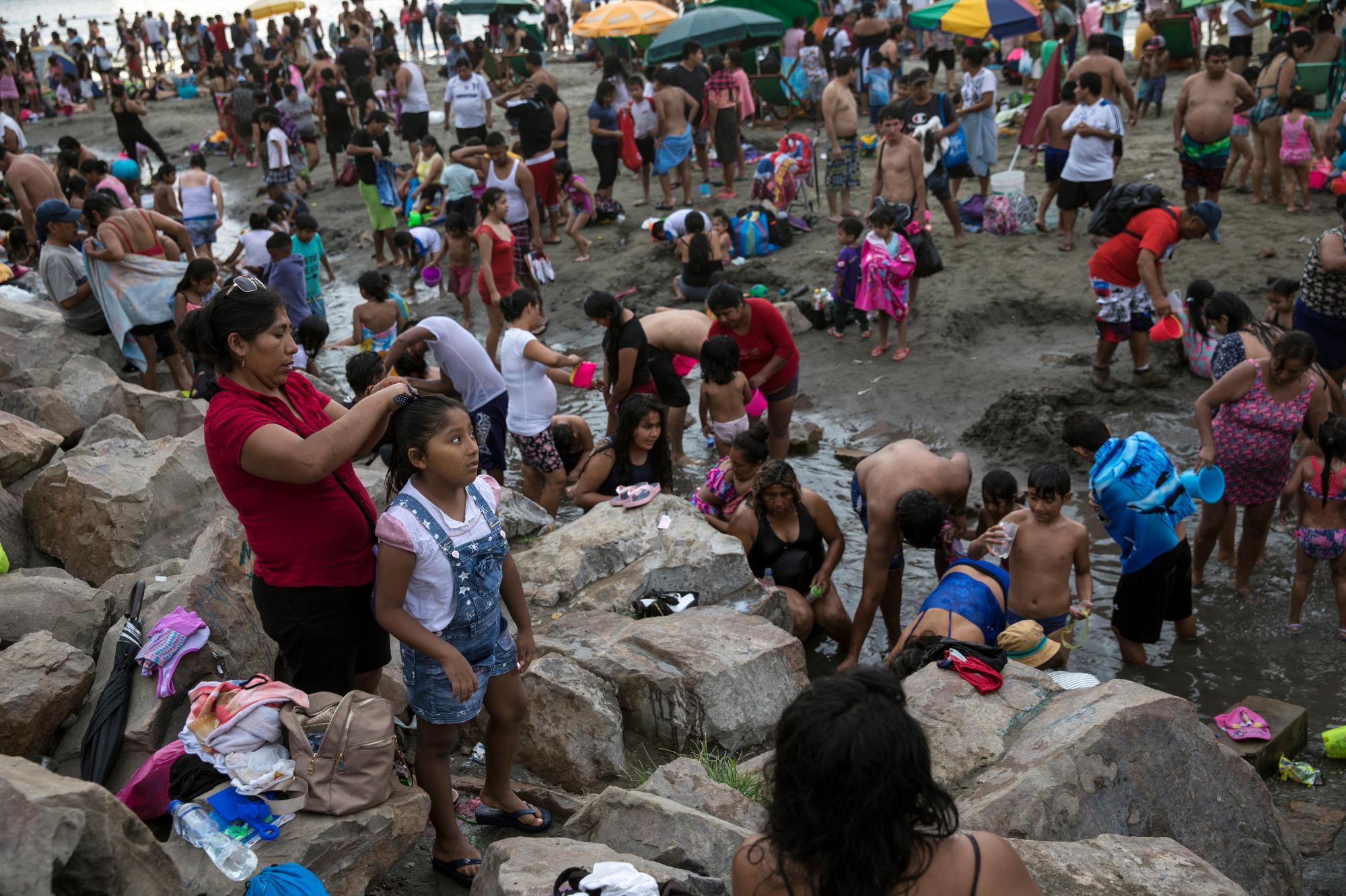 En esta imagen, tomada el 23 de febrero de 2020, los bañistas se visten tras pasar el día en la playa de Agua Dulce, en Lima, Perú. La mayoría de los bañistas van y vuelven a sus casas en transporte público desde el arenal ubicado a 20 kms (12 millas) del centro de la ciudad. (AP Foto/Rodrigo Abd)
